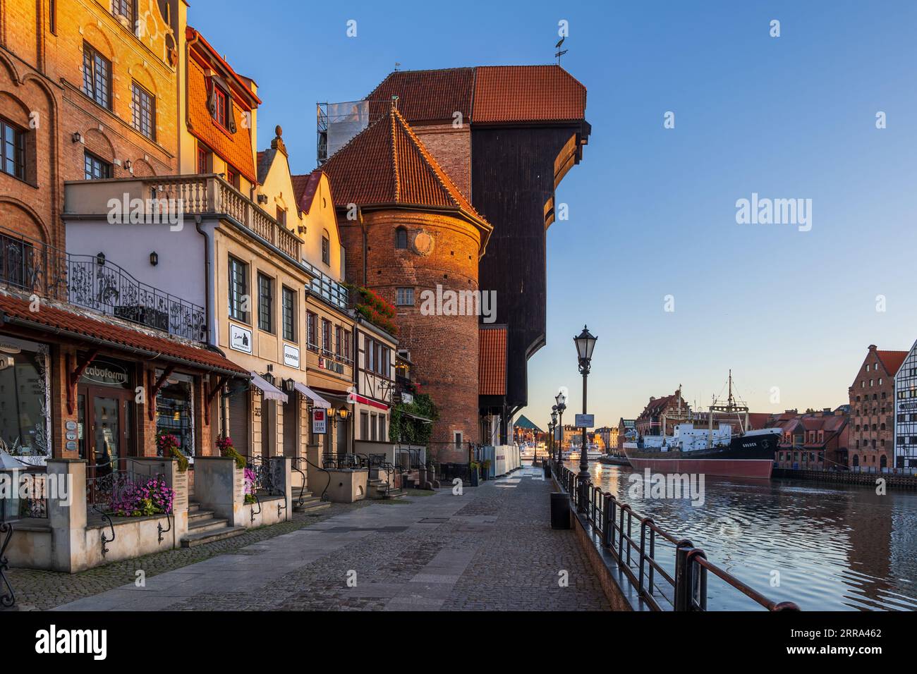 Stadt Gdańsk in Polen, Sonnenaufgang in der Altstadt mit dem Kranich, historische Appartementhäuser an der Straße Long Embankment (Długie Pobrzeże) am Motława Riv Stockfoto