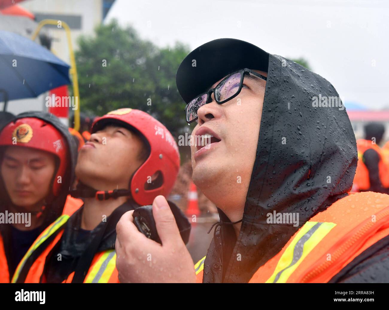 210720 -- JIAOZUO, 20. Juli 2021 -- Ein Feuerwehrmann warnt Dorfbewohner vor Überschwemmungsgefahr durch eine Drohne in der Gemeinde Zhouzhuang, Provinz Xiuwu in Jiaozuo, Provinz Henan in Zentralchina, 20. Juli 2021. Flüsse in Jiaozuo haben einen Anstieg des Wasserspiegels erlebt, als in letzter Zeit ständig Regenfälle die Stadt heimsuchten. Die lokalen Behörden haben Arbeiter zur Hochwasserkontrolle organisiert, die rund um die Uhr in der Stadt patrouillieren und versteckte Gefahren beseitigen, um die Sicherheit von Leben und Eigentum der Menschen zu schützen. CHINA-HENAN-JIAOZUO-SCHWERE NIEDERSCHLAGSBEKÄMPFUNG CN LIXJIANAN PUBLICATIONXNOTXINXCHN Stockfoto