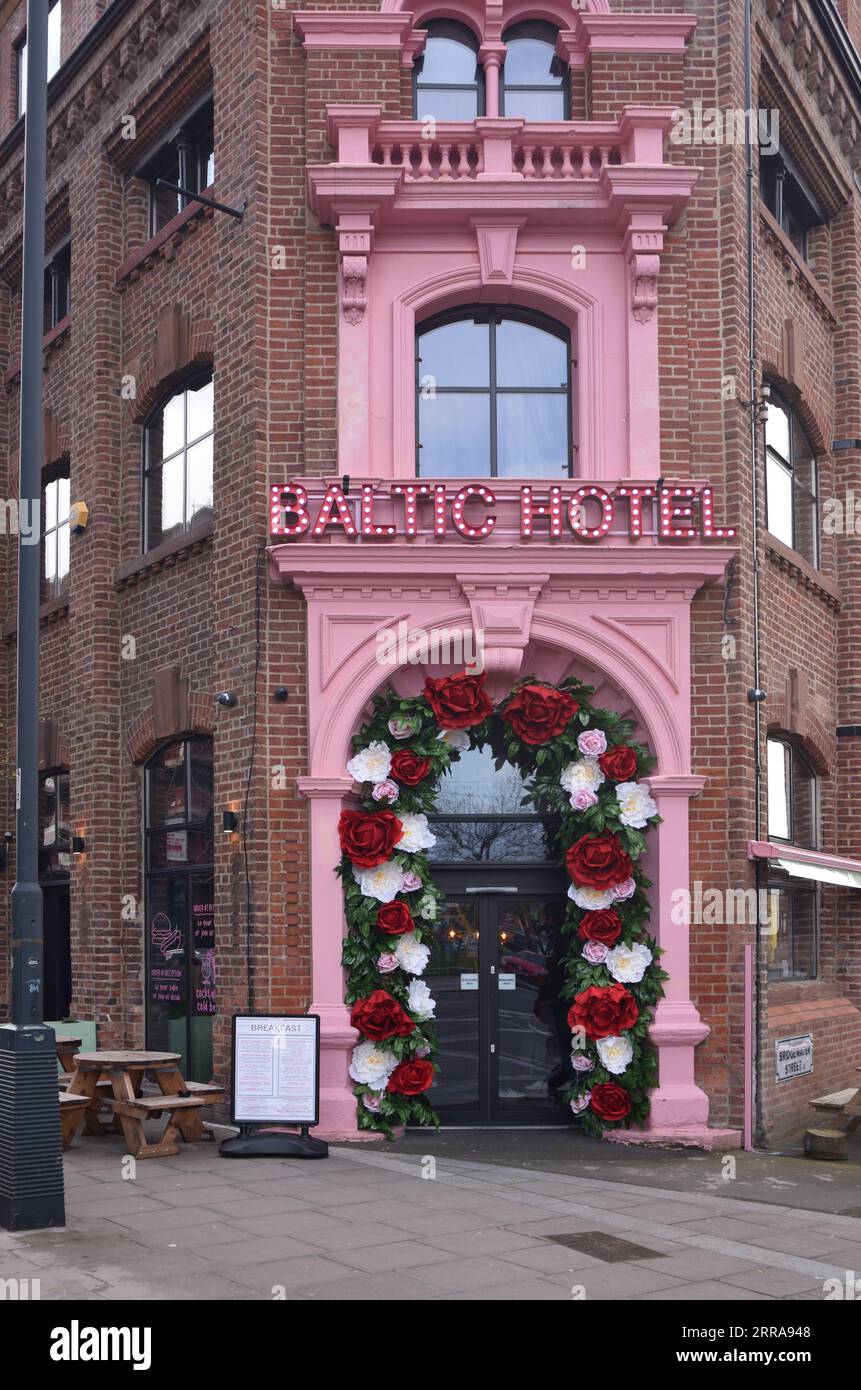Pinkfarbener Eingang mit Ausstellung von Plastikblumen des Baltic Hotels im Baltic Triangle District von Liverpool England Stockfoto