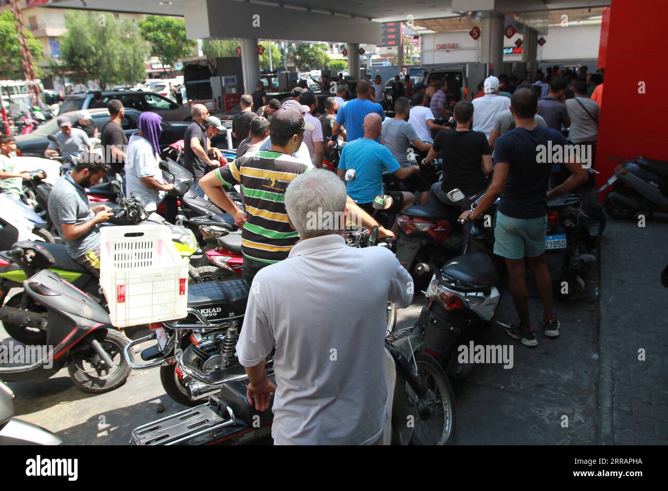 210812 -- TRIPOLI LIBANON, 12. August 2021 -- Motorradfahrer warten am 12. August 2021 an einer Tankstelle in der Stadt Tripoli, Nordlibanon, auf das Betanken von Benzin. Der libanesische Zentralbankgouverneur Riad Salameh kündigte am Mittwoch an, dass die Zentralbank die Subventionen für Treibstoffimporte aufheben werde, berichtete der lokale Fernsehsender al-Jadeed. Dies wird die Kraftstoffkrise im Libanon verschärfen, wo in letzter Zeit vermehrte Stromausfälle und lange Warteschlangen von Autos an Tankstellen zu verzeichnen waren. Foto von /Xinhua LEBANON-TRIPOLI-FUEL CRISIS Khaled PUBLICATIONxNOTxINxCHN Stockfoto