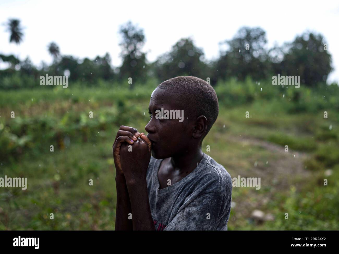 210821 -- SUD, 21. August 2021 -- Ein Junge beobachtet Mitglieder humanitärer Hilfsorganisationen im Bezirk Chardonnieres, Süd, Haiti, am 20. August 2021. Nach Angaben der Katastrophenschutzbehörde der Karibischen Insel wurden in Haiti schwere Schäden und mindestens 2.189 Tote verursacht. HAITI-ERDBEBEN-NACHWIRKUNGEN DAVIDxDExLAxPAZ PUBLICATIONxNOTxINxCHN Stockfoto