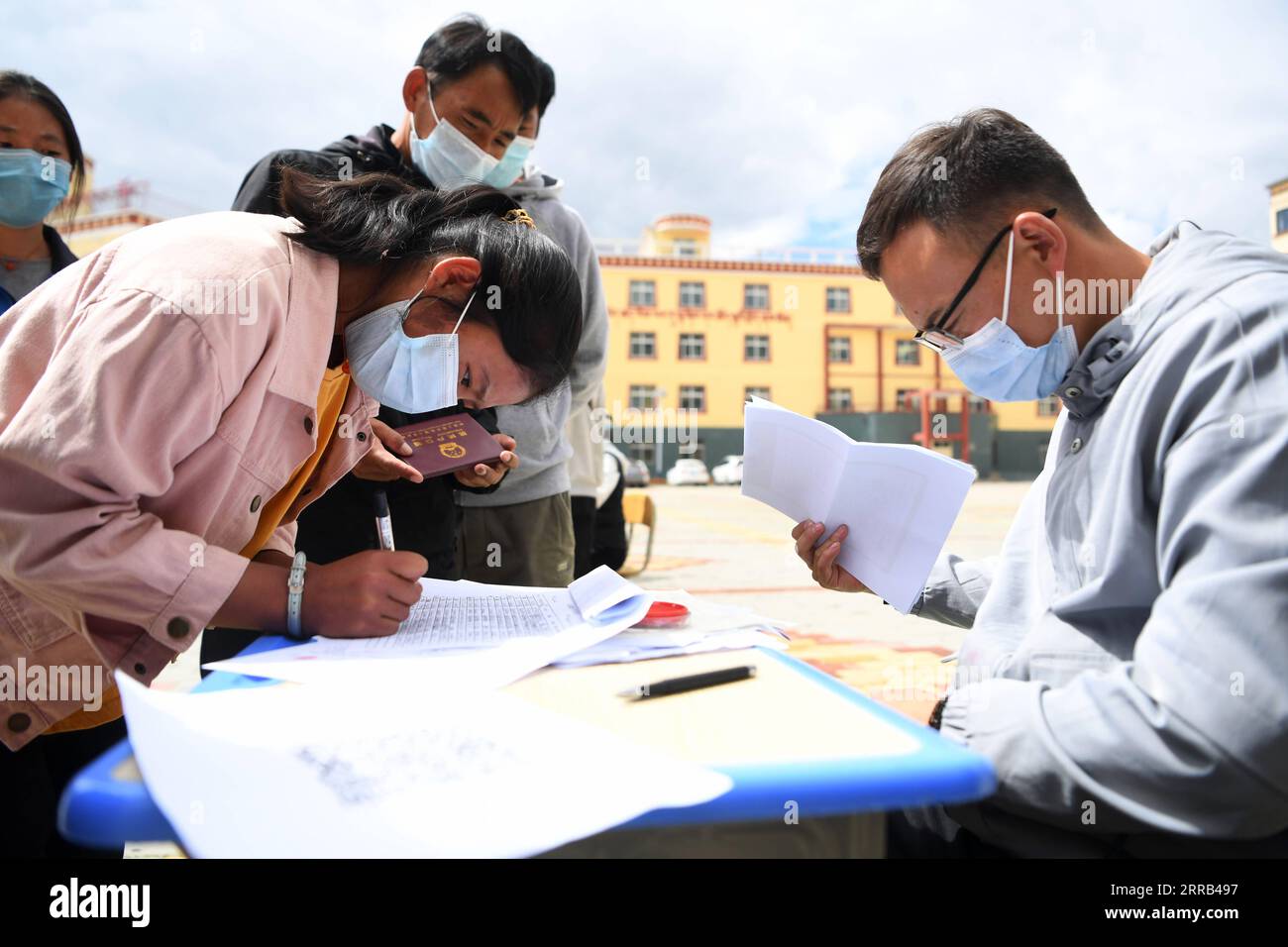 210831 -- GANNAN, 31. August 2021 -- Eine Schülerin der zehnten Klasse registriert ihre Informationen an der Luqu Tibetan Middle School im Luqu County, Gannan Tibetan Autonomous Prefecture, Nordwest-China, Provinz Gansu, 30. August 2021. Auf einer Höhe von 3.200 Metern gelegen, ist die Luqu Tibetan Middle School das einzige Internat im Luqu County mit mehr als 2.500 Schülern, die an der Schule studieren und leben. Die Schüler kommen überwiegend aus Grünland und Weidegebieten. Die Schule begrüßte ihr neues Semester am Montag mit Vorsorgemaßnahmen gegen COVID-19. CHINA-GANSU-GANNAN-LUQU TIBETISCHE MITTELSCHULE Stockfoto