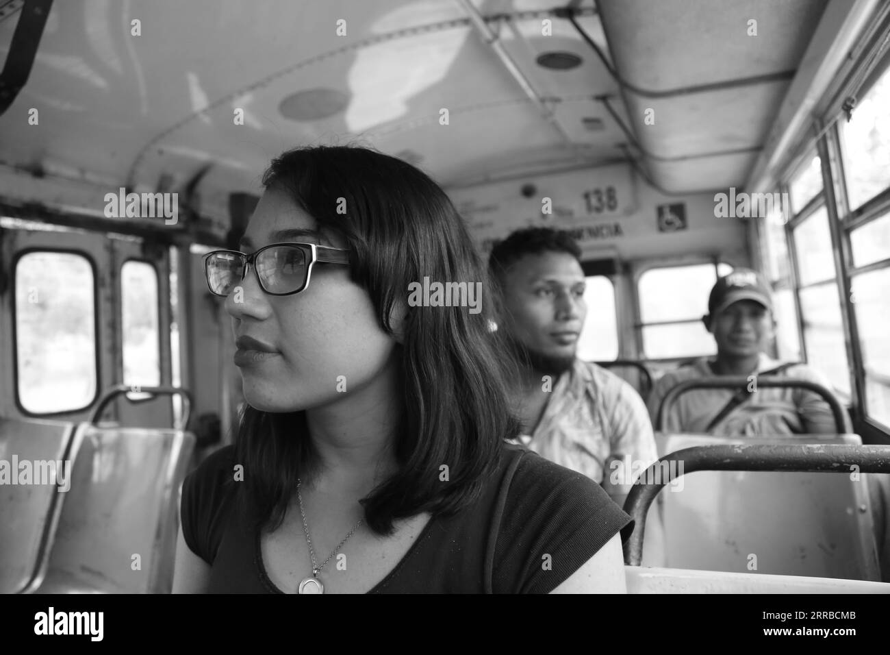 Talamanca, Costa Rica - 17. März 2016: Volksgruppen aus Zentralamerika im Bus. Junge Dame im Vordergrund. Schwarz-weiß Stockfoto