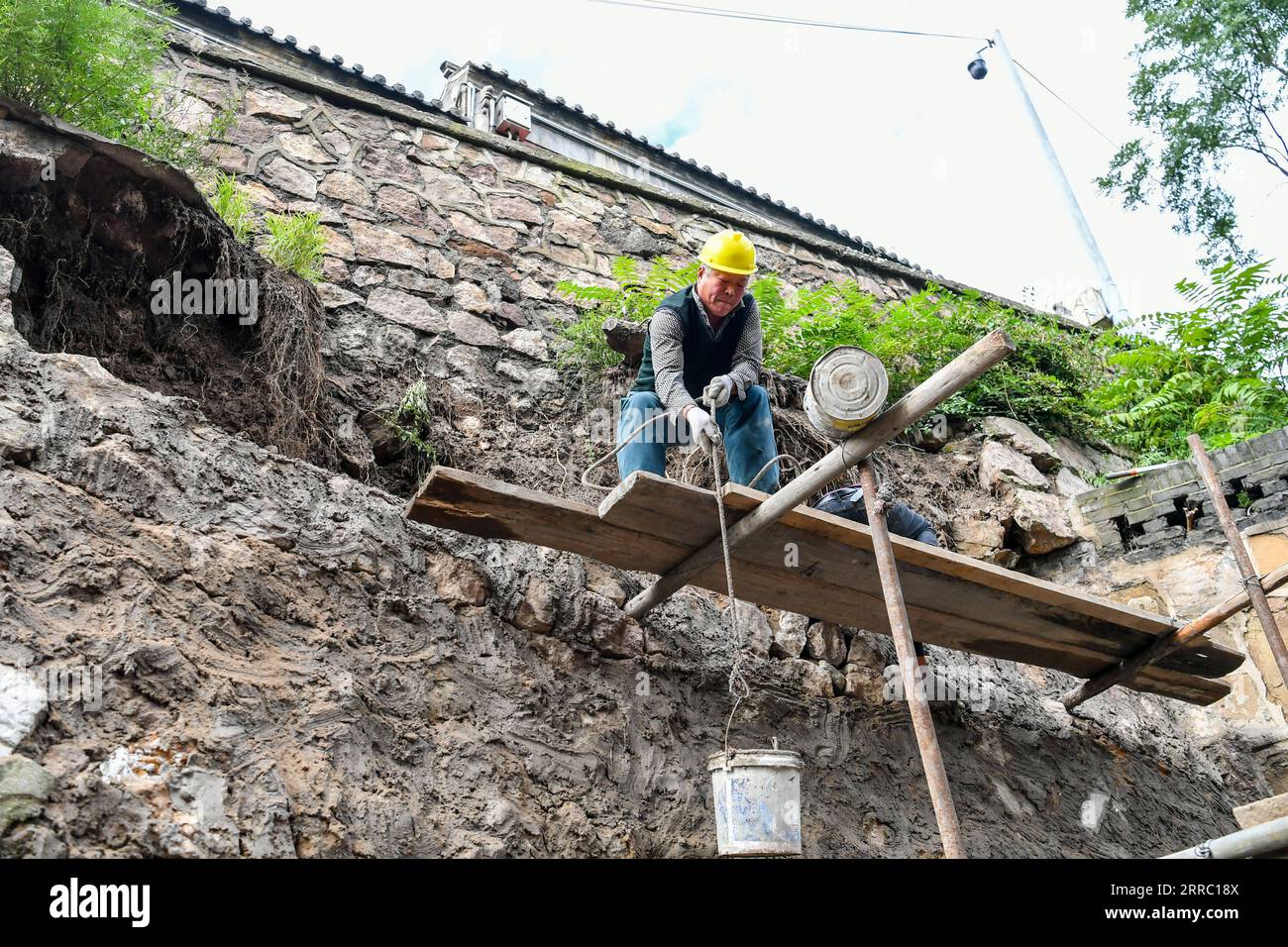 211012 -- TAIYUAN, 12. Oktober 2021 -- Ein Arbeiter hebt Reparaturmaterialien im Jinci Temple Museum in Taiyuan, Hauptstadt der nordchinesischen Provinz Shanxi, 12. Oktober 2021 auf. Shanxi wurde kürzlich von ständigen Regenfällen heimgesucht, die in mehreren Teilen der Provinz zu Überschwemmungen führten. Mehr als 1.000 Kulturdenkmäler und Gebäude haben durch das extreme Wetter strukturelle Schäden erlitten. Die örtliche Behörde für Kulturerbe führt Reparaturarbeiten an den Kulturrelikten durch, die bei der jüngsten Überschwemmung beschädigt wurden. CHINA-SHANXI-TAIYUAN-HOCHWASSERREPARATUR CN CAOXYANG PUBLICATIONXNOTXINXCHN Stockfoto