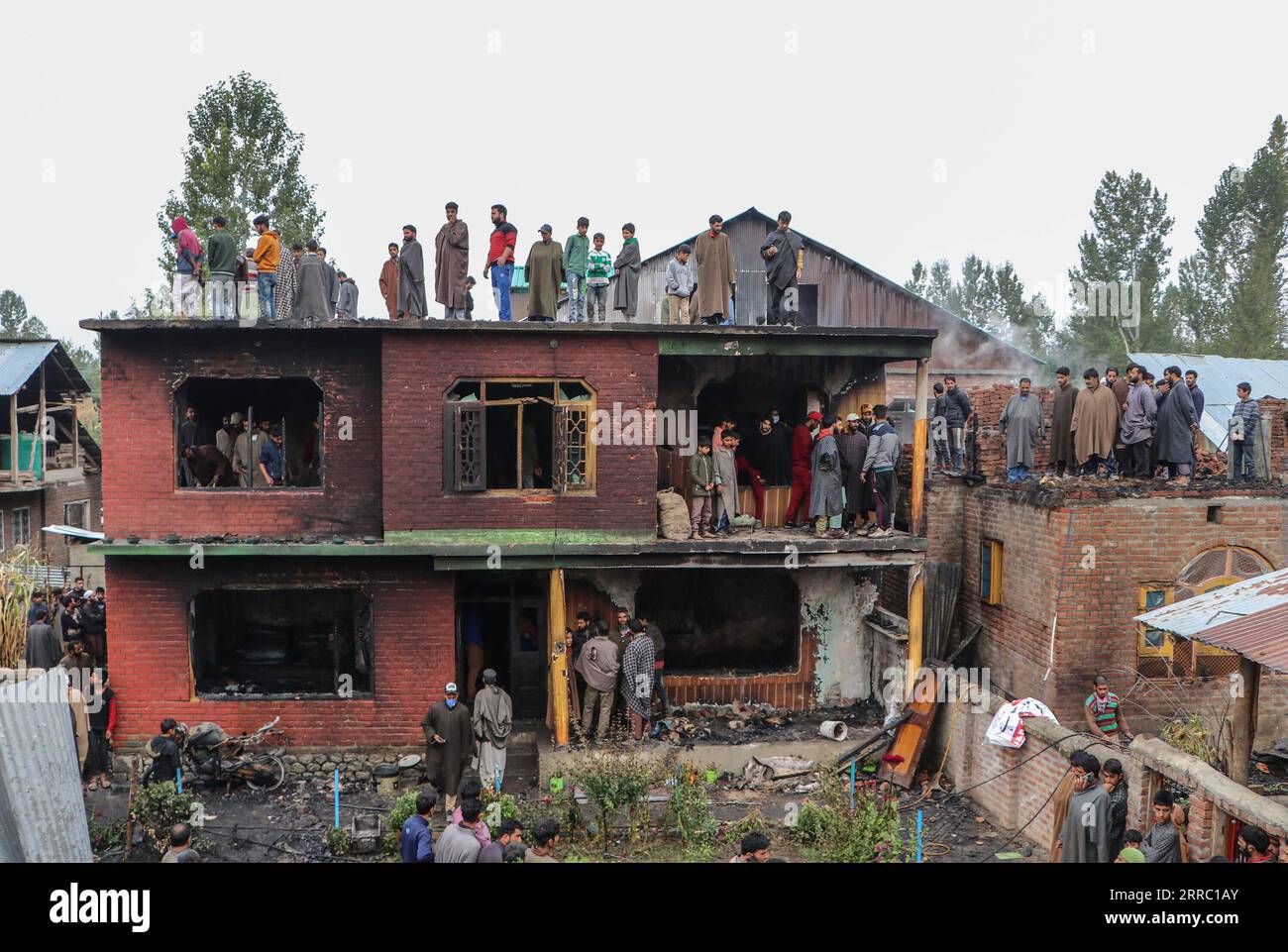 211012 -- SRINAGAR, 12. Oktober 2021 -- Menschen inspizieren ein Haus, das während einer Schießerei in einem Dorf im Bezirk Shopian beschädigt wurde, etwa 62 km südlich von Srinagar, der Sommerhauptstadt des von Indien kontrollierten Kaschmirs, 12. Oktober 2021. Drei Militante wurden am Dienstag in einem heftigen bewaffneten Kampf mit Regierungstruppen im von Indianern kontrollierten Kaschmir getötet, sagte die Polizei. KASCHMIR-SRINAGAR-GUNFIGHT JavedxDar PUBLICATIONxNOTxINxCHN Stockfoto