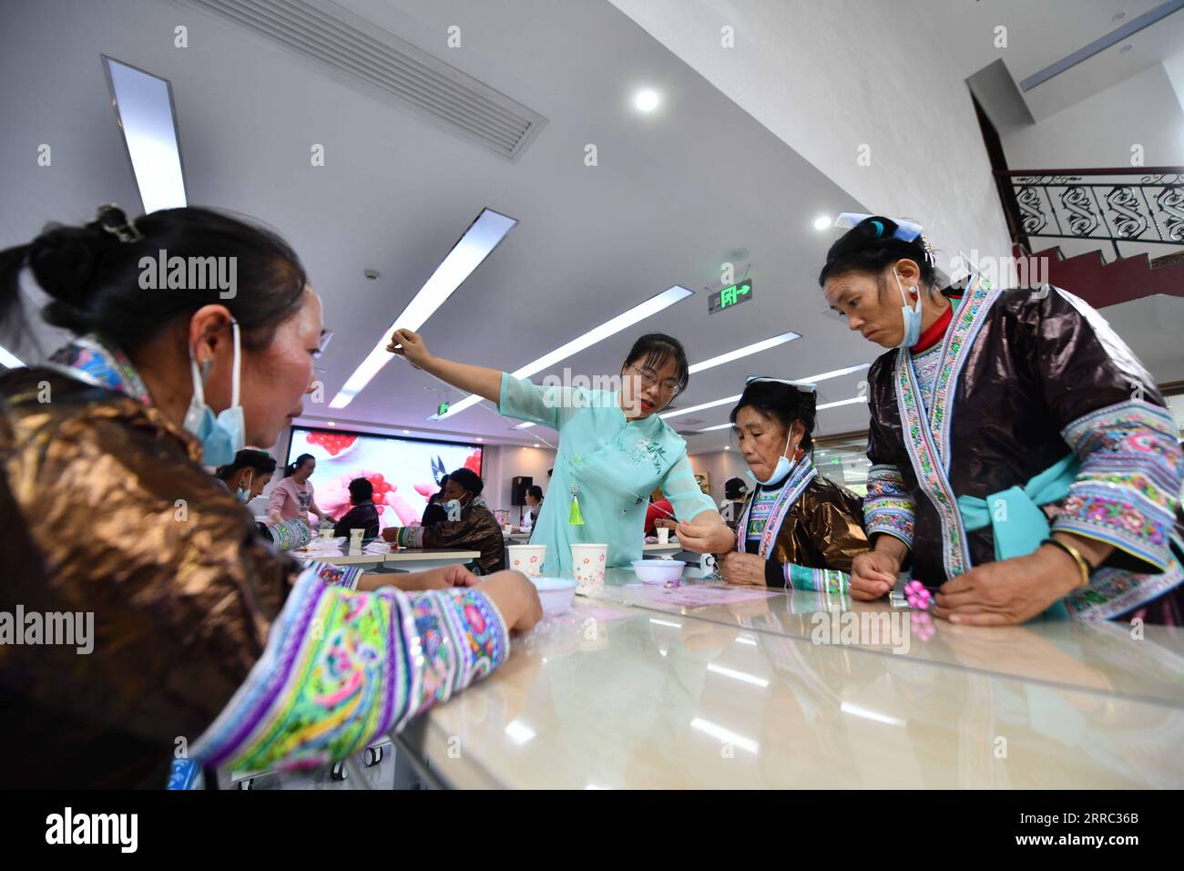 211015 -- LIUZHOU, 15. Oktober 2021 -- ethnische Miao-Frauen lernen in einem Frauenservicezentrum in Liuzhou, südchinesische autonome Region Guangxi Zhuang, 13. Oktober 2021, Kunsthandwerk zu machen. Am Mittwoch und Donnerstag fand in Liuzhou eine Reihe von Austauschaktivitäten für ethnische Miao-Frauen aus Wuying Village statt. Wuying liegt tief in den Bergen an der Grenze zwischen der autonomen Region Guangxi Zhuang und der Provinz Guizhou und ist ein abgelegenes Dorf, das von der ethnischen Gruppe der Miao bewohnt wird, in dem Frauen über 40 kaum jemals eine Schule besucht haben. Seit März 2020 haben die Kommunen ein Trai-System in Betrieb genommen Stockfoto