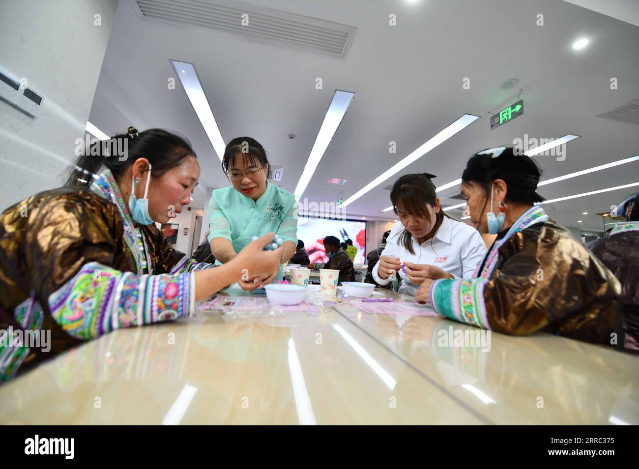 211015 -- LIUZHOU, 15. Oktober 2021 -- ethnische Miao-Frauen lernen in einem Frauenservicezentrum in Liuzhou, südchinesische autonome Region Guangxi Zhuang, 13. Oktober 2021, Kunsthandwerk zu machen. Am Mittwoch und Donnerstag fand in Liuzhou eine Reihe von Austauschaktivitäten für ethnische Miao-Frauen aus Wuying Village statt. Wuying liegt tief in den Bergen an der Grenze zwischen der autonomen Region Guangxi Zhuang und der Provinz Guizhou und ist ein abgelegenes Dorf, das von der ethnischen Gruppe der Miao bewohnt wird, in dem Frauen über 40 kaum jemals eine Schule besucht haben. Seit März 2020 haben die Kommunen ein Trai-System in Betrieb genommen Stockfoto