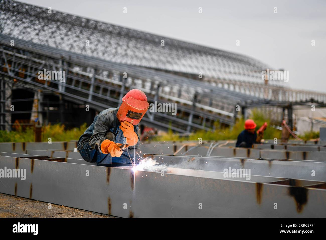 211016 -- QIAN AN, 16. Oktober 2021 -- Ein Arbeiter schweißt Baumaterialien auf der Baustelle eines Straßen-Schienen-Projekts in Qian an Ctiy, nordchinesische Provinz Hebei, 16. September 2021. Qian an in der Provinz Hebei ist ein wichtiger Bezirk in der Stahlindustrie in Nordchina, mit einer großen Nachfrage nach Rohstoffen wie Eisenerz, Kohle und Koks. Um die Verschmutzung und die Verkehrsüberlastung durch den Straßentransport von Massengütern zu verringern, wurden spezielle Eisenbahnlinien für wichtige Eisen- und Stahlunternehmen im Rahmen eines „Road-to-Rail“-Systems gebaut, das den Weg für eine umweltfreundlichere und effizientere Entwicklung ebnete Stockfoto