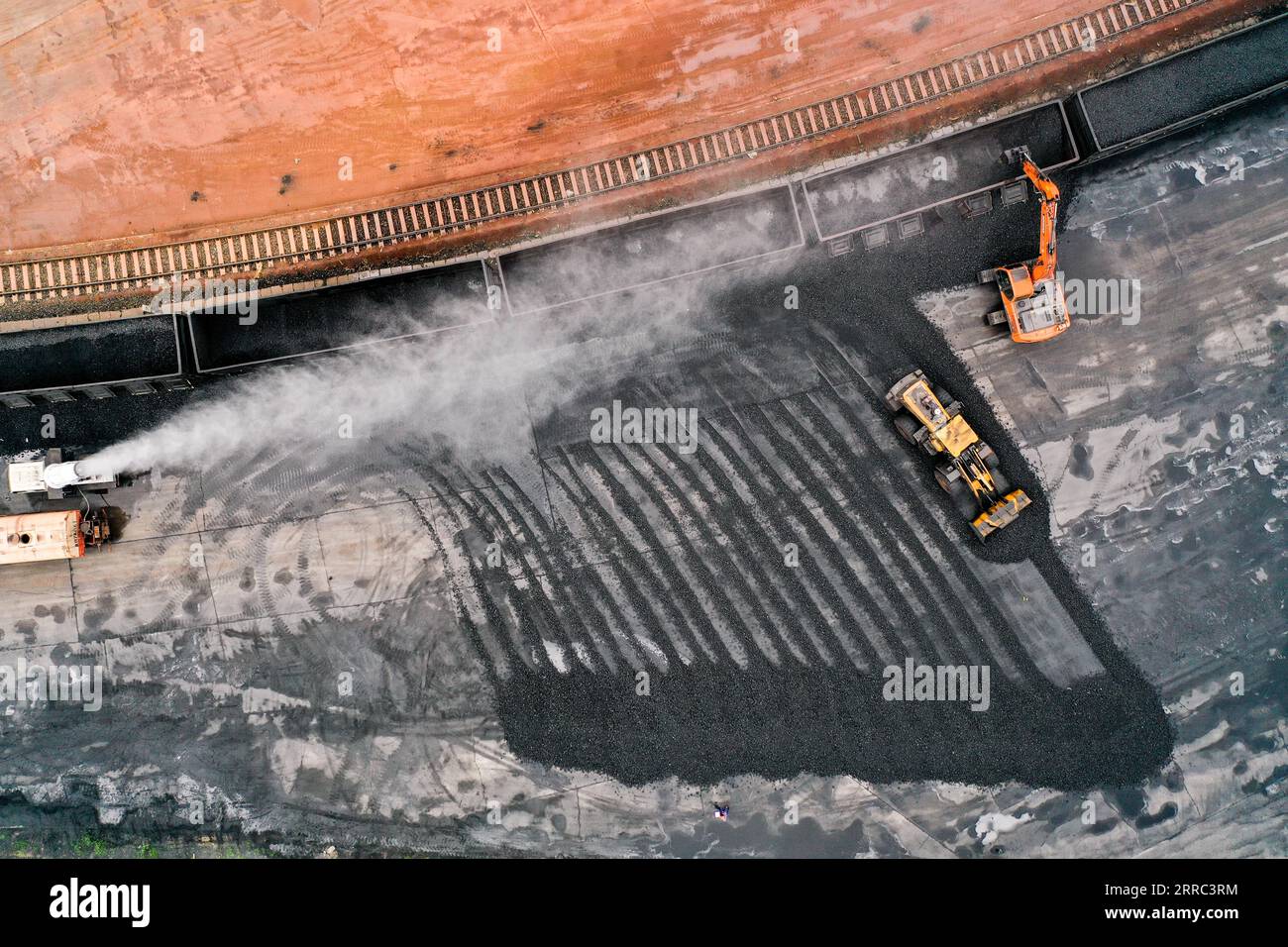211016 -- QIAN AN, 16. Oktober 2021 -- Luftaufnahme aufgenommen am 16. September 2021 zeigt Transportfahrzeuge, die Koks aus einem Zug unter Staubkontrolle auf einem Logistikhof in Qian an Ctiy, Provinz Hebei, entladen. Qian an in der Provinz Hebei ist ein wichtiger Bezirk in der Stahlindustrie in Nordchina, mit einer großen Nachfrage nach Rohstoffen wie Eisenerz, Kohle und Koks. Um die Umweltverschmutzung und die Verkehrsüberlastung durch den Straßentransport von Massengütern zu verringern, wurden spezielle Eisenbahnlinien für wichtige Eisen- und Stahlunternehmen im Rahmen eines Road-to-Rail-Systems gebaut, das die Straßenverkehrsinfrastruktur erleichtert Stockfoto