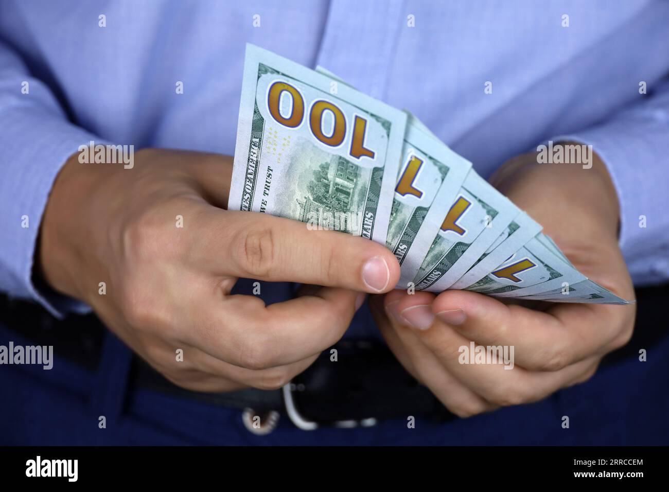 US-Dollar in männlichen Händen aus nächster Nähe, Mann in Geschäftskleidung zählt das Geld. Konzept der Bestechung, des Gehalts, der finanziellen Unterstützung oder des Darlehens Stockfoto