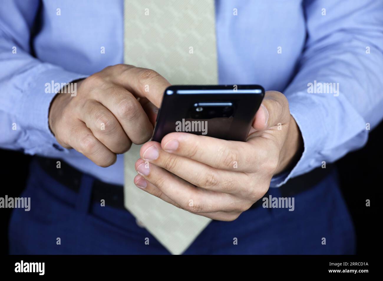 Mann in Bürokleidung, der das Smartphone in den Händen hält. Konzept der Online-Kommunikation, sms Stockfoto