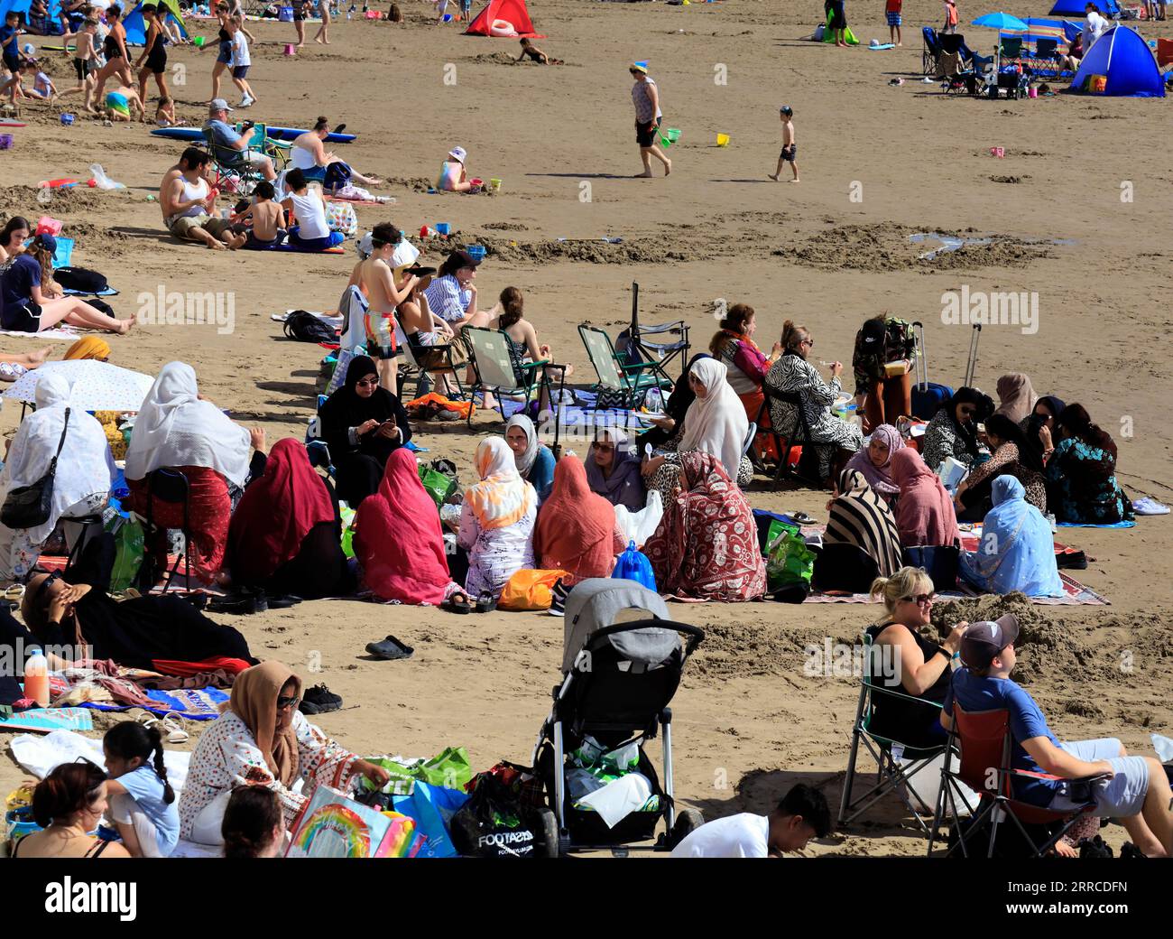 Frauen aus ethnischen Minderheiten, die am Strand von Barry Island picknicken, genießen den heißesten Tag des Jahres. September 2023. Stockfoto