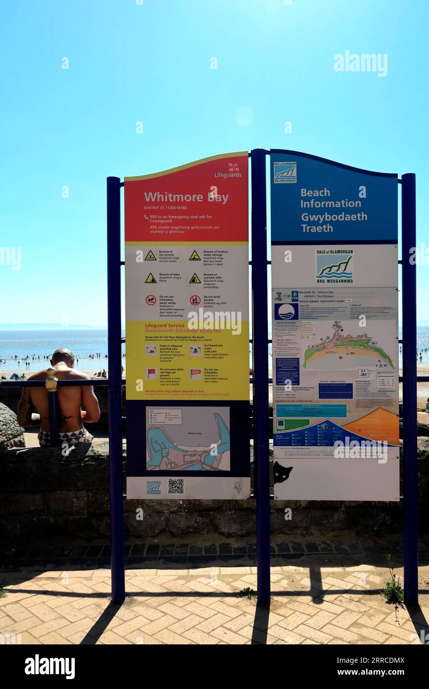 Unterschreiben Sie für Whitmore Bay Beach Information auf Barry Island, und Mann mit Tätowierung daneben, September 2023 Stockfoto