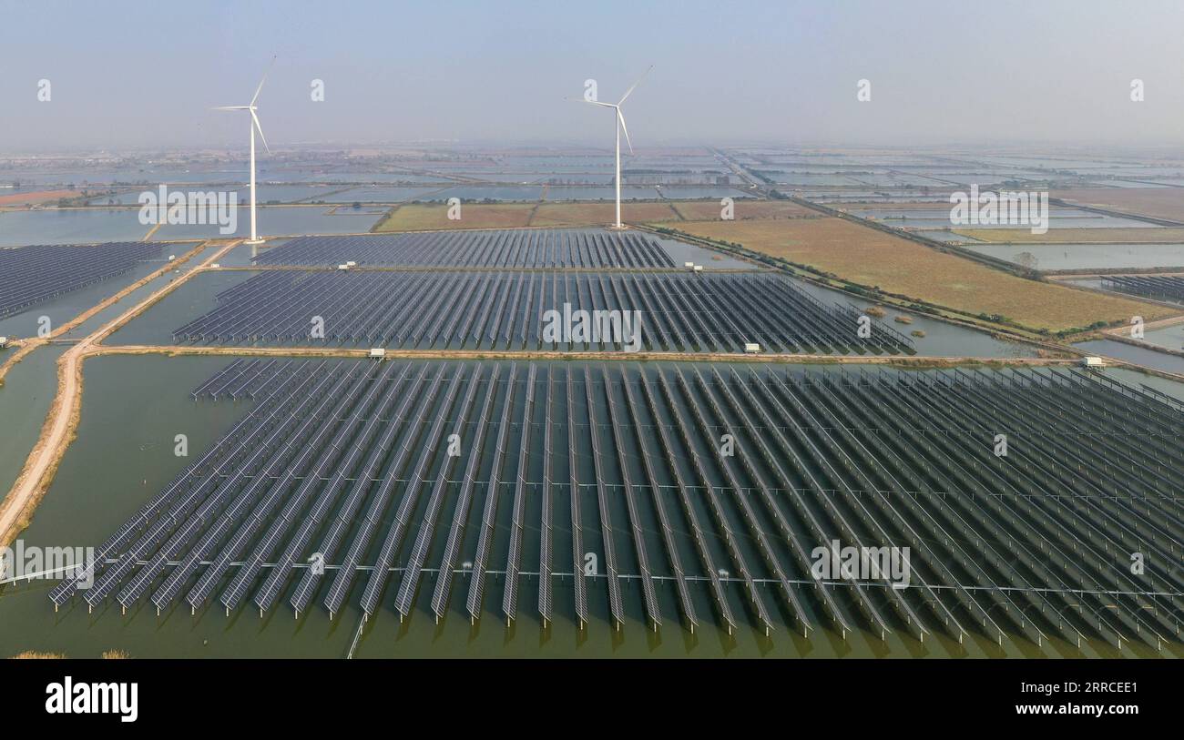 211103 -- YANGZHOU, 3. Nov. 2021 -- Luftaufnahme vom 3. Nov. 2021 zeigt ein Photovoltaik- und Windkraftprojekt, das über den Fischereigewässern in der Township Sheyanghu im Baoying County von Yangzhou in der ostchinesischen Provinz Jiangsu installiert wurde. Das Baoying County in Yangzhou hat in den letzten Jahren durch die Förderung von Solar- und Windenergie die grüne Entwicklung gefördert. Die jährliche Stromerzeugung aus sauberer Energie des Countys erreicht jetzt 2,1 Milliarden kWh, was 84 Prozent des jährlichen Stromverbrauchs des Countys entspricht, was einer Senkung des Kohleverbrauchs um 840.000 Tonnen entspricht. CHINA-JIANGSU-BAOYING- Stockfoto