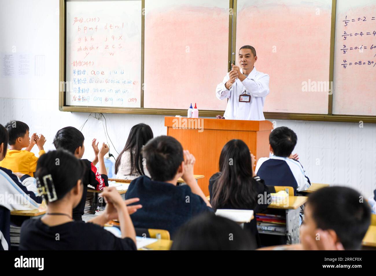 211104 -- DAXIN, 4. November 2021 -- Zhao Jianbai demonstriert die richtige Art der Handwäsche für Grundschüler im Dorf Ren ai, Gemeinde Xialei, Provinz Daxin in der südchinesischen autonomen Region Guangxi Zhuang, 3. November 2021. Zhao Jianbai, ein Einheimischer aus dem Dorf Ren ai an der Grenze zwischen China und Vietnam, dient seit seiner beruflichen Ausbildung als Dorfarzt und kehrte 1998 in seine Heimatstadt zurück. Ren Ai, fernab in bergigen Gebieten gelegen, war früher für Kraftfahrzeuge unzugänglich und verfügte nur über knappe medizinische Ressourcen. Wenn sie krank sind, sind die Dorfbewohner meist zufrieden Stockfoto