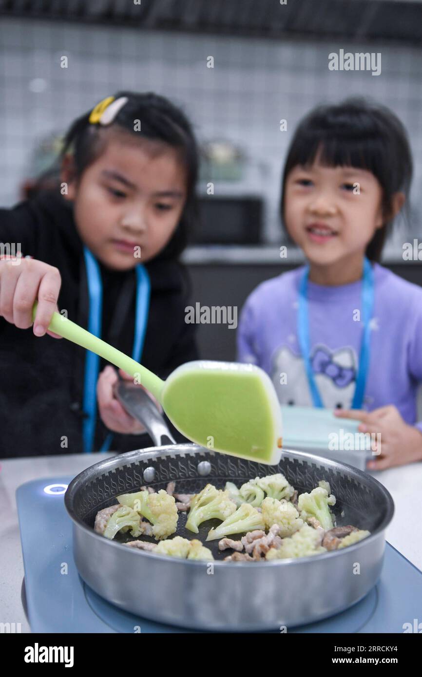 211110 -- FOSHAN, 10. November 2021 -- Schüler lernen im Little Chef Trainingszentrum in der Xishan Grundschule im Bezirk Shunde der Stadt Foshan, Provinz Guangdong in Südchina, 9. November 2021 zu kochen. Die Xishan Primary School in Shunde hat seit September dieses Jahres ein kleines Kochzentrum auf dem Schulcampus in Zusammenarbeit mit der Shunde Fengchu Vocational Skills Training School eingerichtet, das den Schülern jeden Tag einen Kochkurs von 45 Minuten nach der Schule bietet. Professionelle Kochlehrer geben zusammen mit Schullehrern Kochkurse für verschiedene Altersgruppen im Training cen Stockfoto