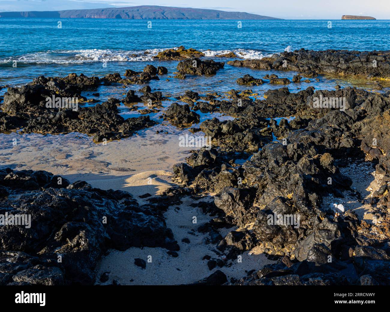 Wellen, die sich über Lava am Little Beach mit Kaho'olawe Island und Molokini on the Horizon, Makena Beach State Park, Maui, Hawaii, USA ergießen Stockfoto