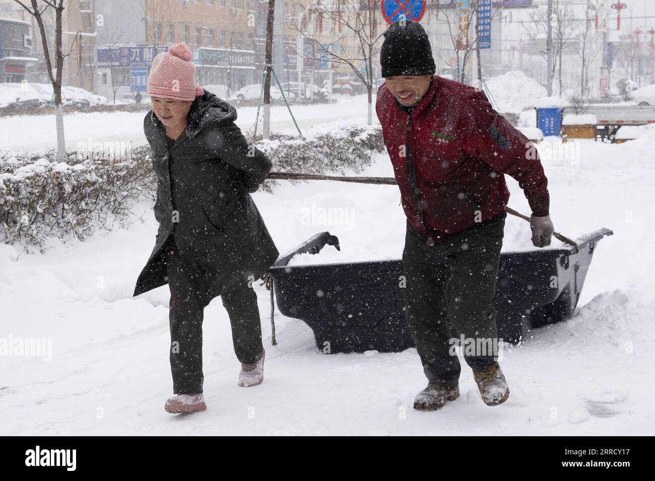 211122 -- JIXI, 22. November 2021 -- Menschen räumen Schnee von ihrem Wohngebiet in Jixi City, nordöstliche chinesische Provinz Heilongjiang, 22. November 2021. Schwere Schneefälle trafen in letzter Zeit viele Teile von Heilongjiang. Mitarbeiter verschiedener Sektoren trotzen eisigen Böen und Schneeflocken, um die normale Verfügbarkeit wesentlicher öffentlicher Dienste zu gewährleisten. CHINA-HEILONGJIANG-BLIZZARD CN ZhangxTao PUBLICATIONxNOTxINxCHN Stockfoto