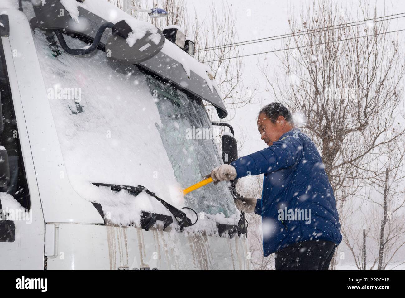 211122 -- HEGANG, 22. November 2021 -- Ein Arbeiter entfernt Schnee vom Windschild eines Schneepfluges in der Stadt Hegang, Provinz Heilongjiang im Nordosten Chinas, 22. November 2021. Schwere Schneefälle trafen in letzter Zeit viele Teile von Heilongjiang. Mitarbeiter verschiedener Sektoren trotzen eisigen Böen und Schneeflocken, um die normale Verfügbarkeit wesentlicher öffentlicher Dienste zu gewährleisten. CHINA-HEILONGJIANG-BLIZZARD CN XiexJianfei PUBLICATIONxNOTxINxCHN Stockfoto