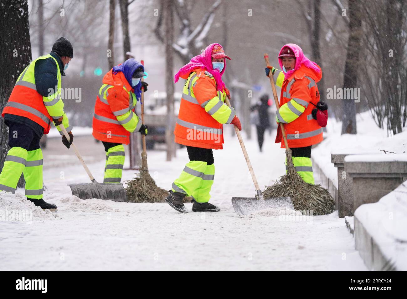 211122 -- HARBIN, 22. November 2021 -- Sanitäter räumen Schnee von einer Straße in Harbin City, nordöstliche chinesische Provinz Heilongjiang, 22. November 2021. Schwere Schneefälle trafen in letzter Zeit viele Teile von Heilongjiang. Mitarbeiter verschiedener Sektoren trotzen eisigen Böen und Schneeflocken, um die normale Verfügbarkeit wesentlicher öffentlicher Dienste zu gewährleisten. CHINA-HEILONGJIANG-BLIZZARD CN WangxJianwei PUBLICATIONxNOTxINxCHN Stockfoto