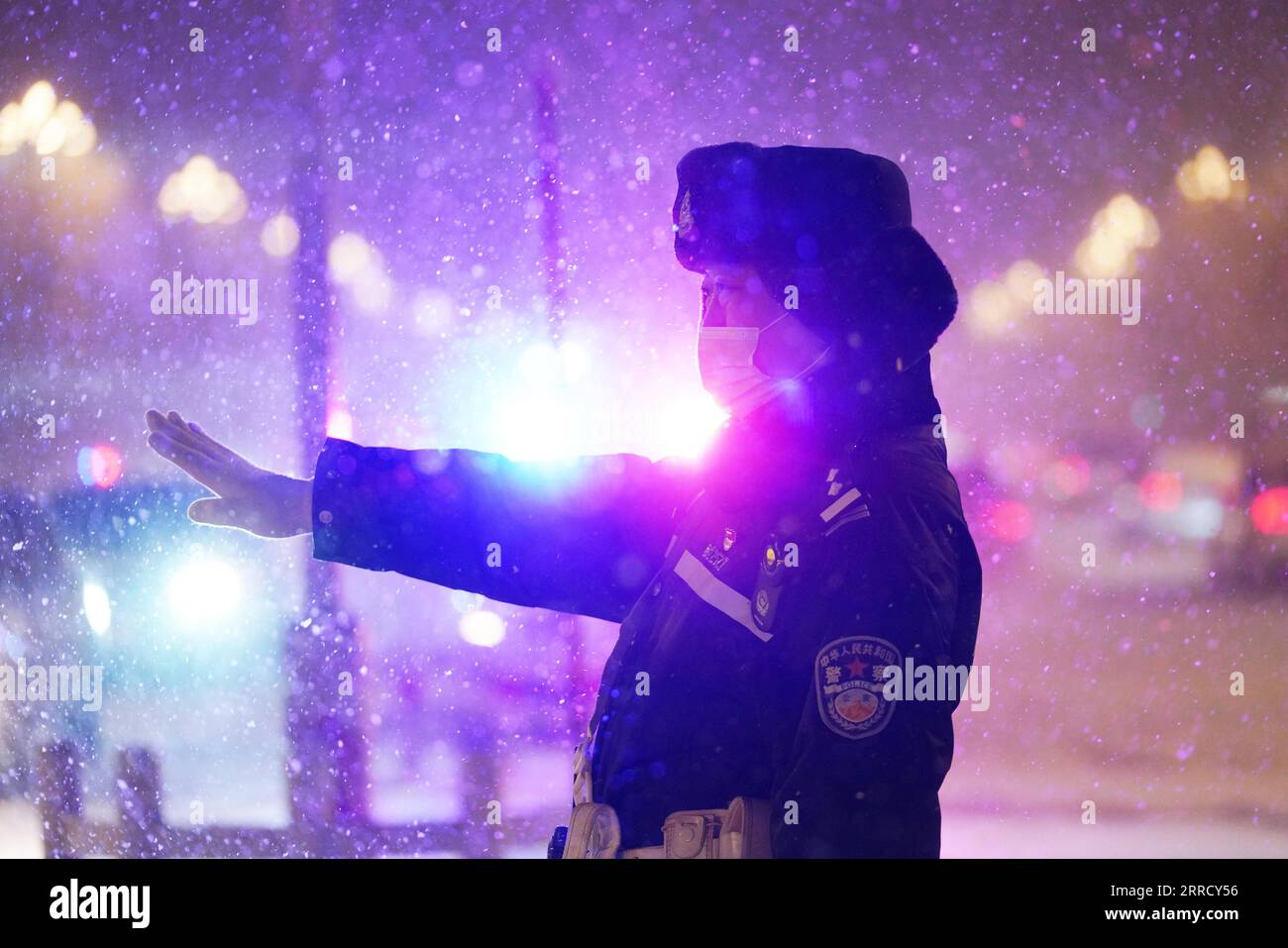 211122 -- HARBIN, 22. November 2021 -- Ein Polizeibeamter leitet den Verkehr im Schnee in der Stadt Harbin, Provinz Heilongjiang im Nordosten Chinas, 22. November 2021. Schwere Schneefälle trafen in letzter Zeit viele Teile von Heilongjiang. Mitarbeiter verschiedener Sektoren trotzen eisigen Böen und Schneeflocken, um die normale Verfügbarkeit wesentlicher öffentlicher Dienste zu gewährleisten. CHINA-HEILONGJIANG-BLIZZARD CN WangxJianwei PUBLICATIONxNOTxINxCHN Stockfoto