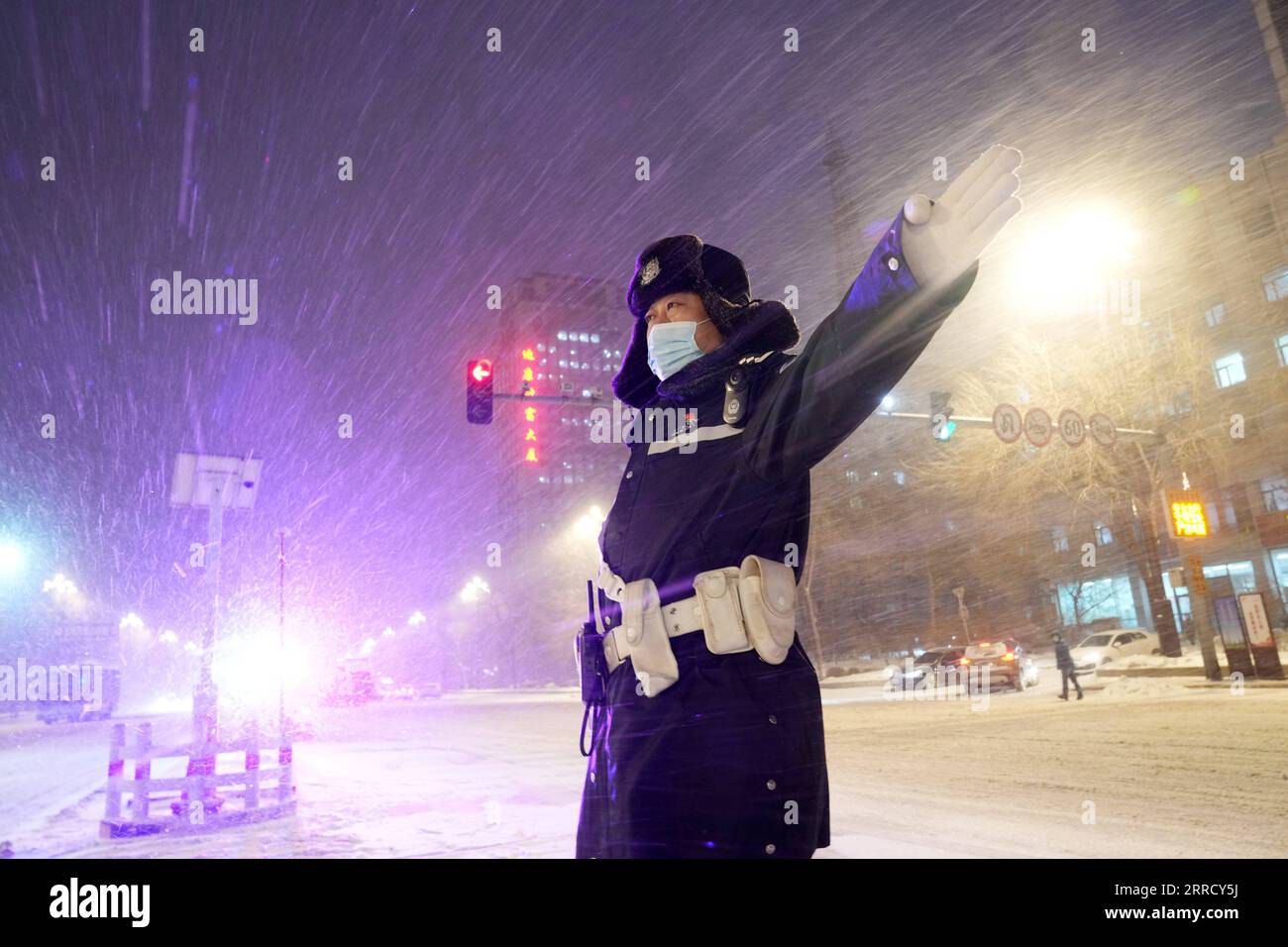 211122 -- HARBIN, 22. November 2021 -- Ein Polizeibeamter leitet den Verkehr im Schnee in der Stadt Harbin, Provinz Heilongjiang im Nordosten Chinas, 22. November 2021. Schwere Schneefälle trafen in letzter Zeit viele Teile von Heilongjiang. Mitarbeiter verschiedener Sektoren trotzen eisigen Böen und Schneeflocken, um die normale Verfügbarkeit wesentlicher öffentlicher Dienste zu gewährleisten. CHINA-HEILONGJIANG-BLIZZARD CN WangxJianwei PUBLICATIONxNOTxINxCHN Stockfoto