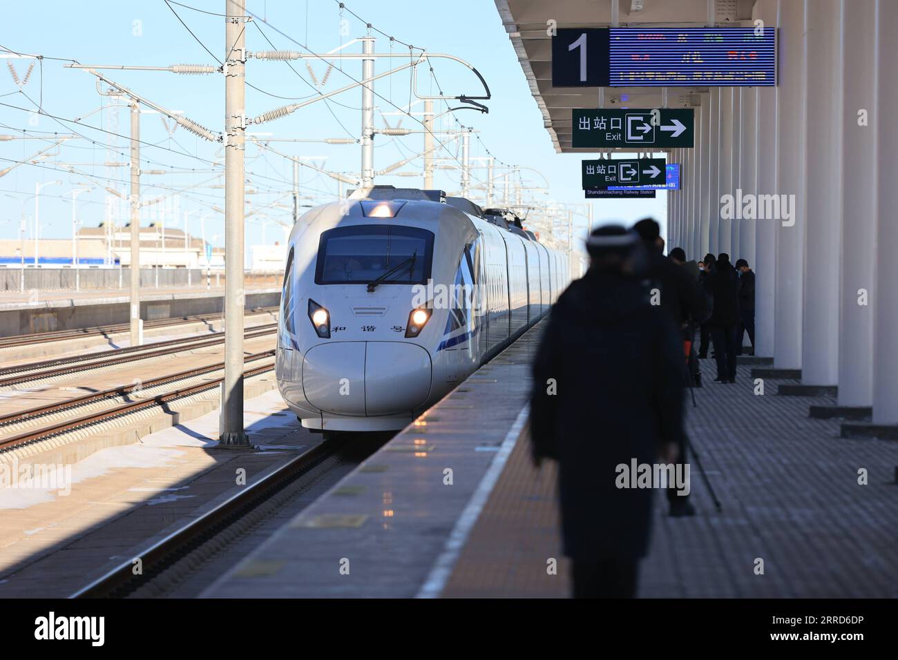 211205 -- ZHANGYE, 5. Dezember 2021 -- am Bahnhof der Lanzhou-Xinjiang Railway in Shandan County, Stadt Zhangye, Provinz Gansu im Nordwesten Chinas, 5. Dezember 2021, fährt Ein Hochgeschwindigkeitszug Ein. Der Bahnhof Shandan Horse Ranch in einer Höhe von über 3.000 Metern nahm am Sonntag seinen Betrieb auf. Schnellzüge, die Passagiere nach Lanzhou, Xi an, Ürümqi, Jiayuguan und Dunhuang bringen können, fahren jeden Tag in den Bahnhof. Die Lanzhou-Xinjiang-Eisenbahn verbindet die nordwestchinesische Provinz Gansu mit der autonomen Region Xinjiang Uygur. Das Shan liegt im Qilian-Gebirge Stockfoto