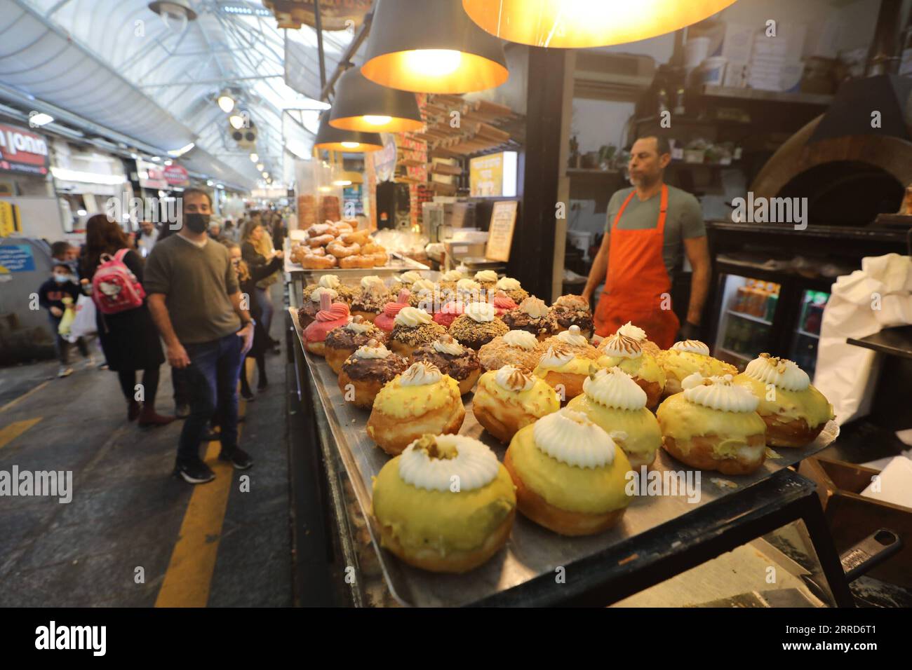 211206 -- JERUSALEM, 6. Dezember 2021 -- Ein Verkäufer verkauft Sufganiyots, runde Gelee-Donuts, die auf dem jüdischen Festival von Hanukka während Hanukkah in Jerusalem am 6. Dezember 2021 gegessen werden. Foto: /Xinhua MIDEAST-JERUSALEM-HANUKKAH-DONUTS MuammarxAwad PUBLICATIONxNOTxINxCHN Stockfoto