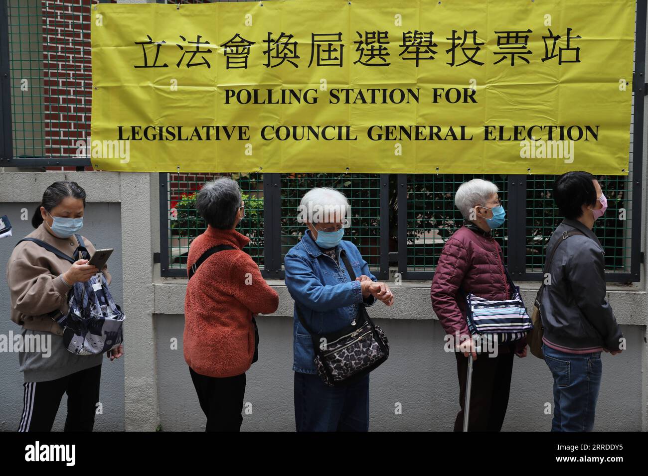 211219 -- HONGKONG, 19. Dezember 2021 -- Wähler warten auf die Wahl in einer Wahlstation in Wan Chai in Hongkong, Südchina, 19. Dezember 2021. Die Wahl zum Legislativrat LegCo der Sonderverwaltungsregion Hongkong (HKSAR) für die siebte Amtszeit begann am Sonntagmorgen, der ersten seit der Verbesserung des Wahlsystems für die HKSAR. Mehr als 600 Wahllokale eröffneten um 8:30 Uhr Ortszeit (0030 GMT) in ganz Hongkong, wo etwa 4,5 Millionen Wahlberechtigte ihre Stimme abgeben konnten. CHINA-HONGKONG-7. WAHLPERIODE LEGCO CN WUXXIAOCHU PUBLICATIONXNOTXINXCHN Stockfoto