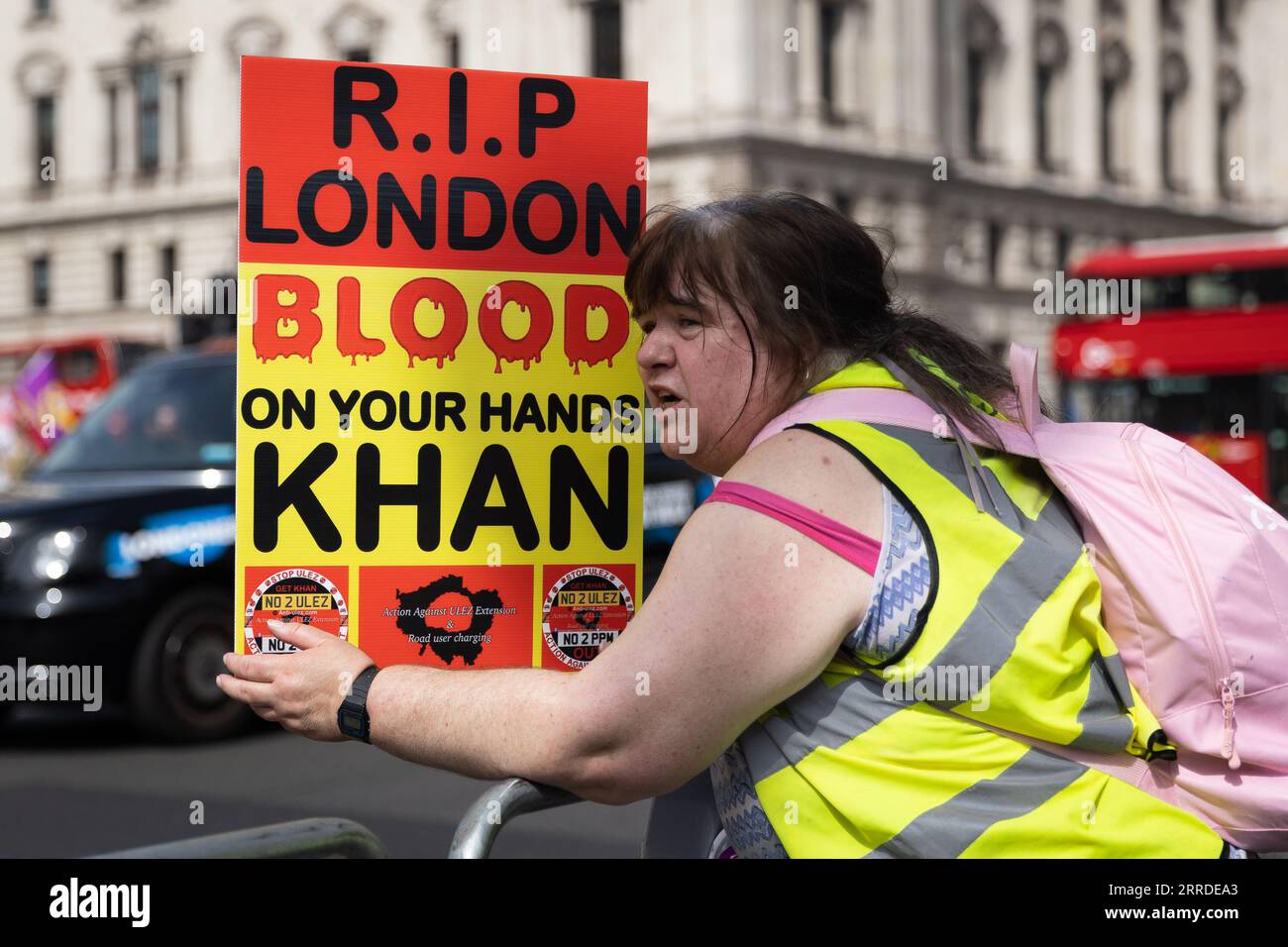 Ein Anti-ULEZ-Demonstrant hält eine Plakette vor dem Parlament in London, da die Erweiterung der ULEZ (Ultra Low Emission Zone) in Kraft tritt. Fahrer in London unterliegen jetzt strengen Umweltschutzvorschriften; sie müssen eine tägliche Gebühr von 12,50 £ zahlen, wenn ihre Fahrzeuge die vorgeschriebenen Emissionsnormen nicht erfüllen. Stockfoto