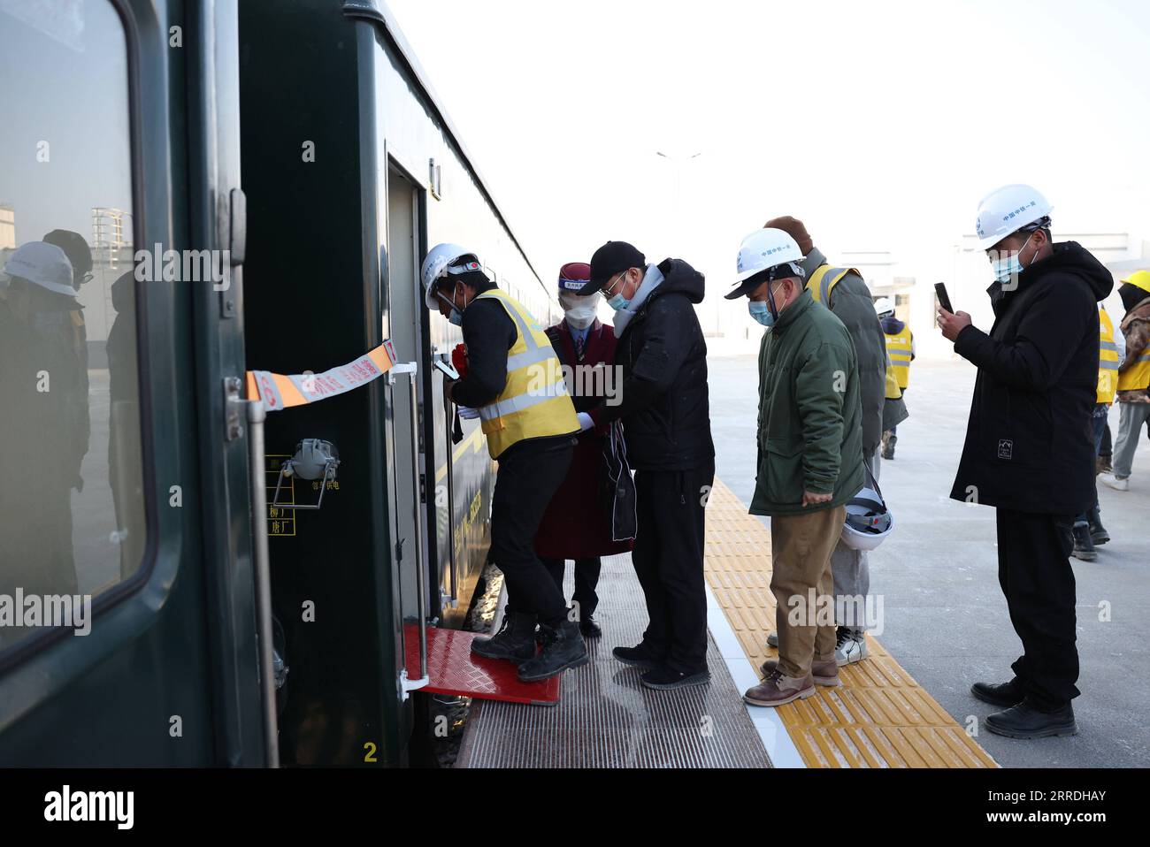 211226 -- JIUQUAN, 26. Dezember 2021 -- Eisenbahnkonstrukteure steigen in den ersten Zug des Abschnitts Jiuqian-Dongfeng der Jiuquan-Ejina Railway am Suzhou Railway Station in der Stadt Jiuquan, Provinz Gansu im Nordwesten Chinas, 26. Dezember 2021. Der Abschnitt Jiuqian-Dongfeng der Eisenbahnverbindung zwischen Jiuquan der nordwestchinesischen Provinz Gansu und Ejina Banner der nordchinesischen Autonomen Region Innere Mongolei nahm nach der Modernisierung am Sonntag seinen Betrieb auf. Der 243,731 km lange Abschnitt durchquert die Wüste Badanjilin. CHINA-GANSU-INNER MONGOLEI-JIUQUAN-EJINA RAILWAY-DONGFENG-SECTION-OPERATION CN CHENXBIN PUBL Stockfoto