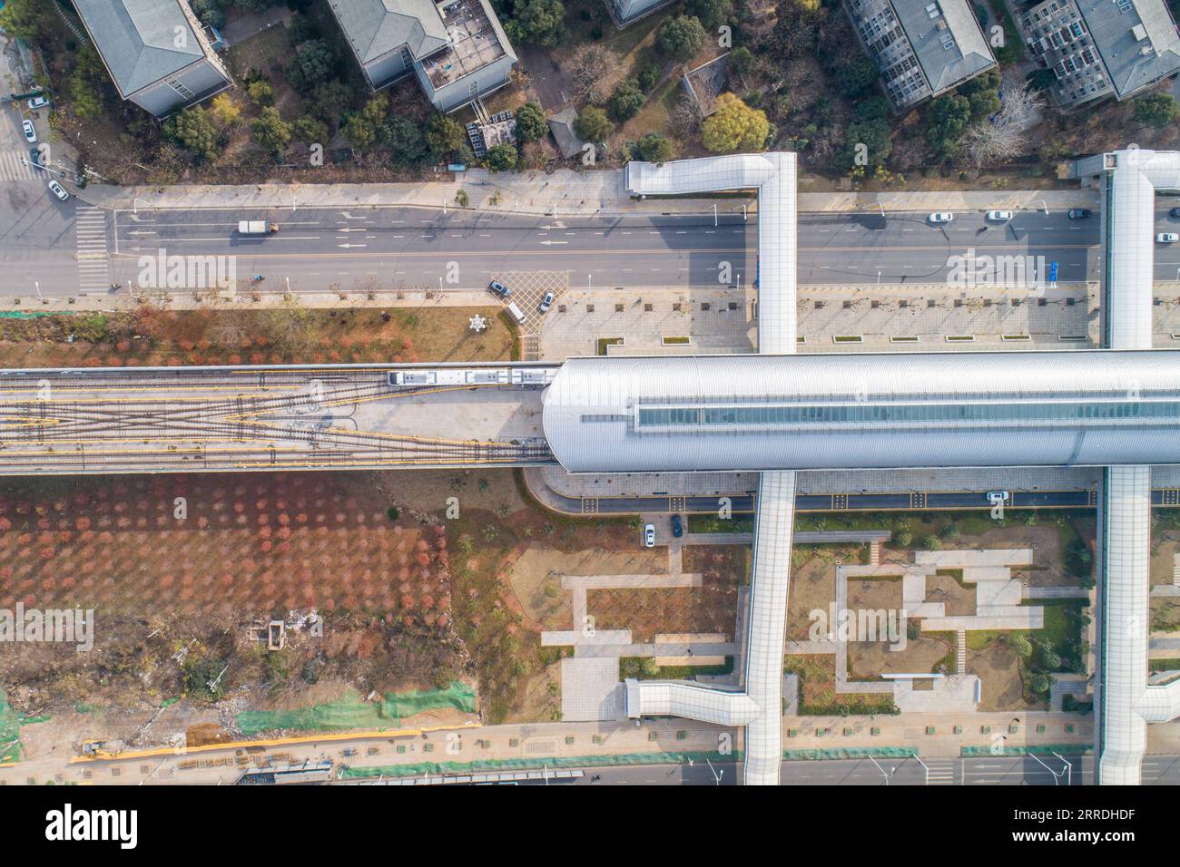 211226 -- WUHAN, 26. Dezember 2021 -- Luftaufnahme vom 26. Dezember 2021 zeigt einen Zug, der von der Hubei University of Chinese Medicine Station der U-Bahn-Linie 5 in Wuhan, der zentralchinesischen Provinz Hubei, abfährt. Drei Stadtbahnlinien in Wuhan wurden am Sonntag für die Öffentlichkeit geöffnet – Linie 5, die zweite Phase der Linie 6, und Linie 16 Hannan mit einer Gesamtlänge von 75,2 km Linie 5 ist Wuhans erste vollautomatische U-Bahn-Linie. Die Linie 16 wird entlang des Yangtze gebaut, mit der höchsten Station auf 30 Metern, die den Passagieren eine schöne Aussicht bietet. Die Gesamtlänge der in Wuhan in Betrieb befindlichen U-Bahn-Schienen beträgt Stockfoto