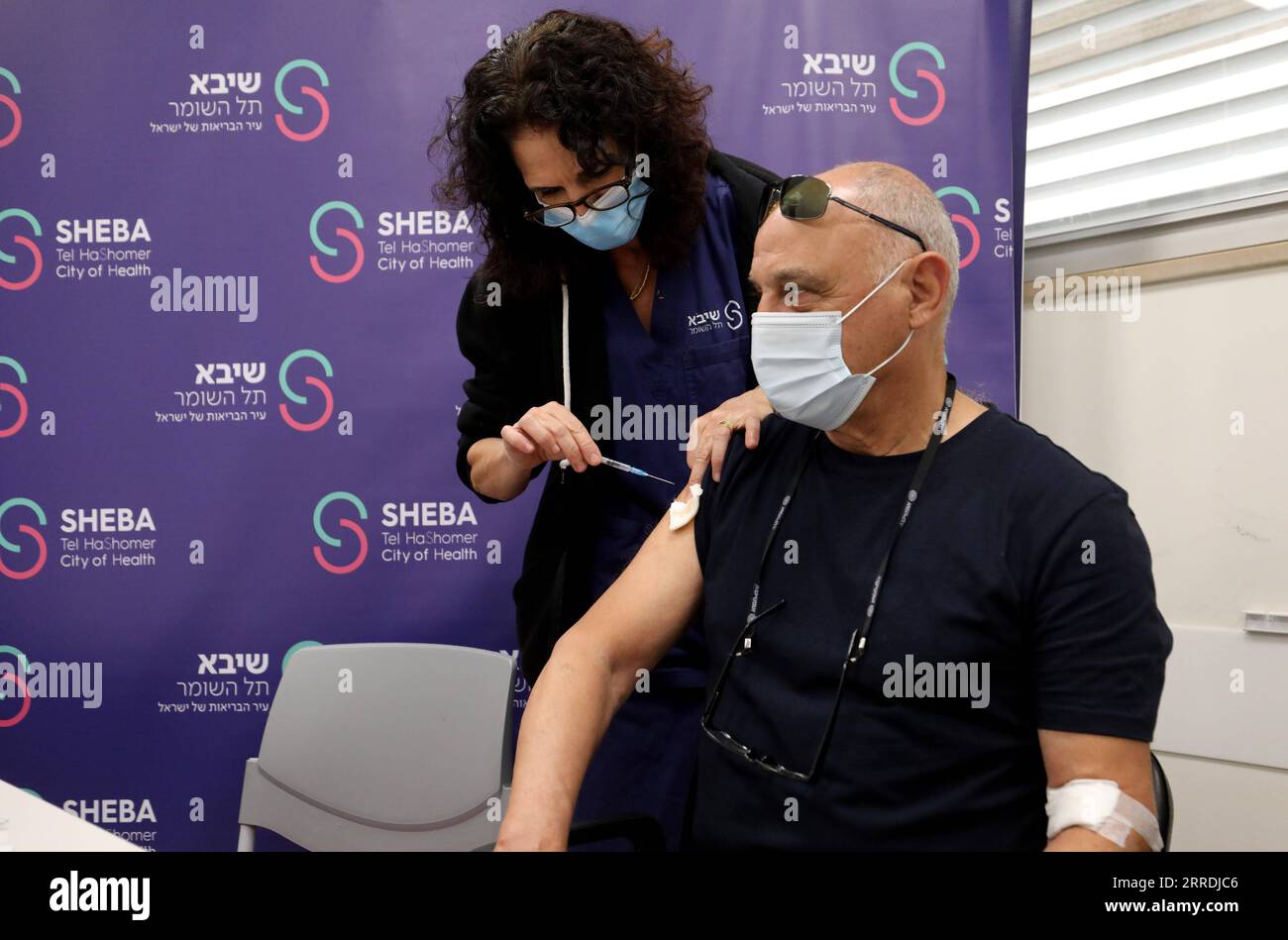 211229 -- RAMAT GAN, 29. Dezember 2021 -- ein israelischer Mann erhält am 28. Dezember 2021 die vierte Dosis COVID-19-Impfstoff im Sheba Medical Center in der zentralisraelischen Stadt Ramat Gan. Israel begann am Montag mit Studien zu einer vierten Dosis Coronavirus-Impfstoff. Foto von /Xinhua ISRAEL-RAMAT GAN-COVID-19-4th DOSE-VACCINE-TRIAL GilxCohenxMagen PUBLICATIONxNOTxINxCHN Stockfoto