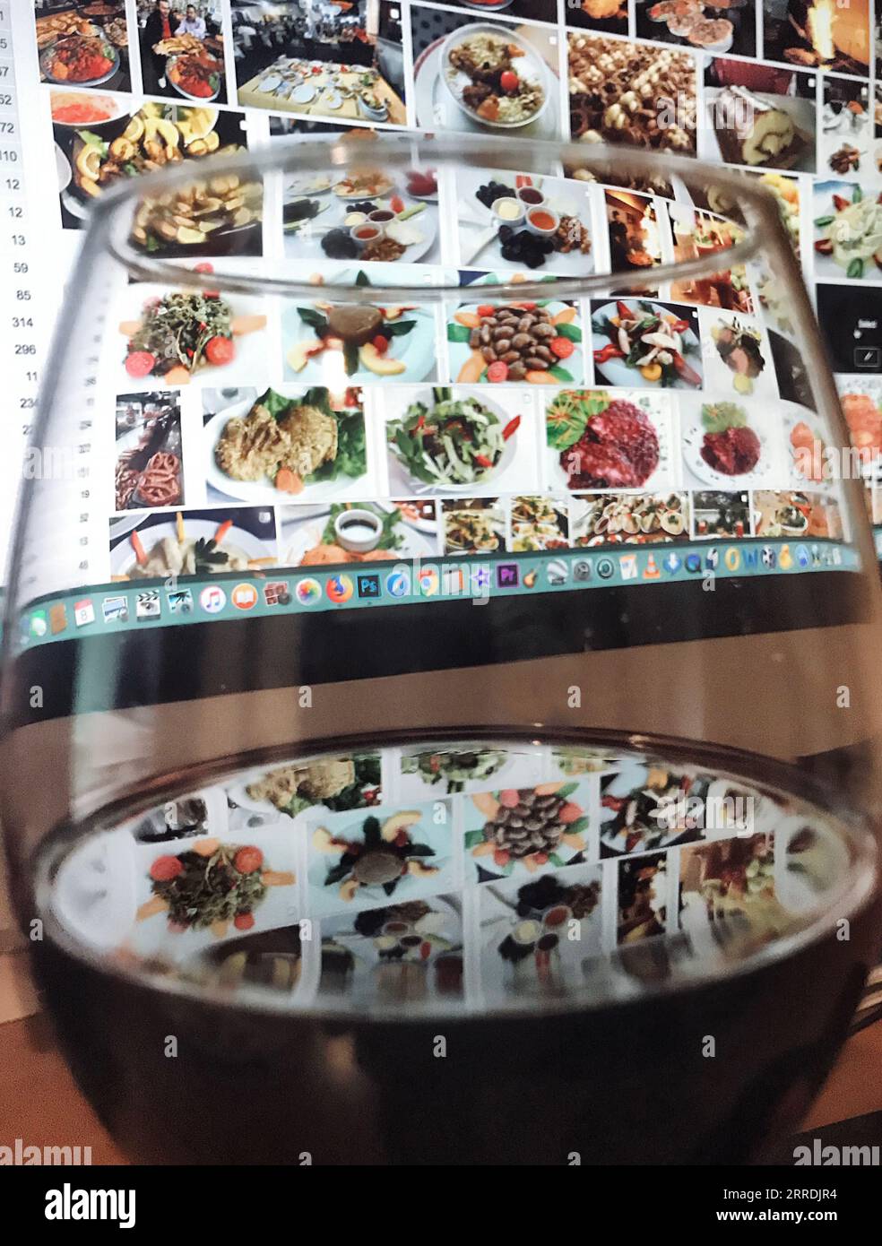 Rotweinglas hinter dem Essen Fotos auf dem Bildschirm. Stockfoto