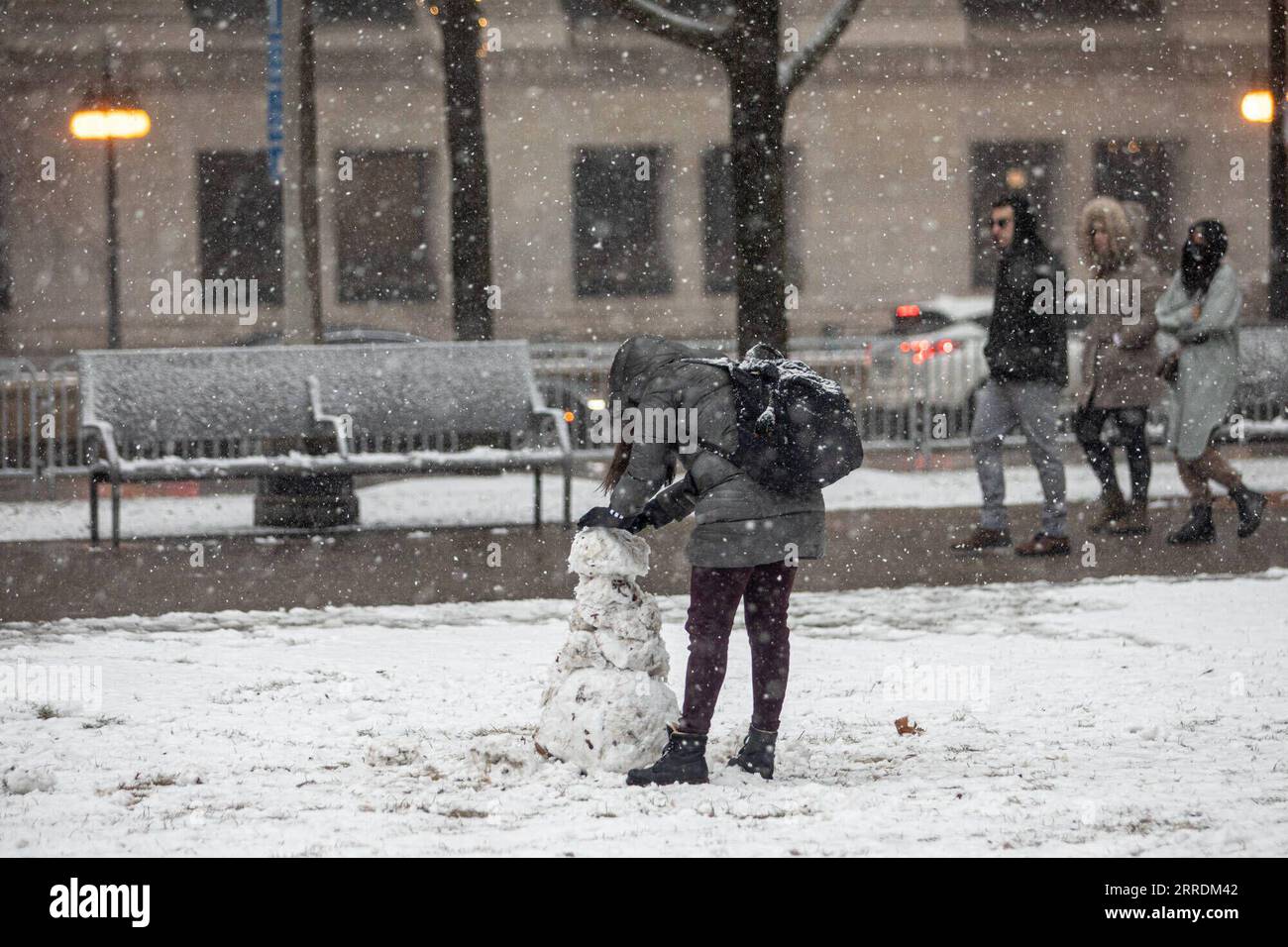 220102 -- CHICAGO, 2. Januar 2022 -- Eine Frau macht am 1. Januar 2022 einen Schneemann in der Innenstadt von Chicago, den Vereinigten Staaten. Ein Wintersturm traf Chicago am Samstag, und die Schneeladung wird voraussichtlich 10 bis 18 Zentimeter erreichen. Foto: /Xinhua U.S.-CHICAGO-WINTER-STORM VincentxD.xJohnson PUBLICATIONxNOTxINxCHN Stockfoto