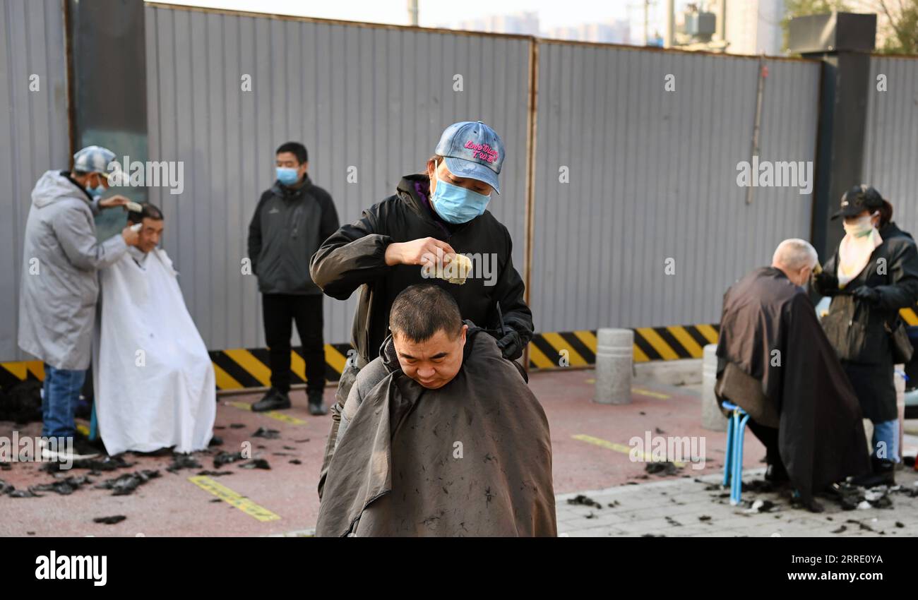 220117 -- XI AN, 17. Jan. 2022 -- Menschen lassen sich in einem Freiluftgebiet in Xi an, Hauptstadt der nordwestchinesischen Provinz Shaanxi, am 17. Jan. 2022 ihre Haare schneiden. Das Leben der Menschen in Xi an ist in einigen Teilen der Stadt allmählich wieder auf Kurs, da die neuen lokal übertragenen COVID-19-Fälle an einem sechsten Tag in Folge am Sonntag auf einstellige Stellen zurückgingen. CHINA-SHAANXI-XI AN-DAILY LIFE-COVID-19 CN TAOXMING PUBLICATIONXNOTXINXCHN Stockfoto