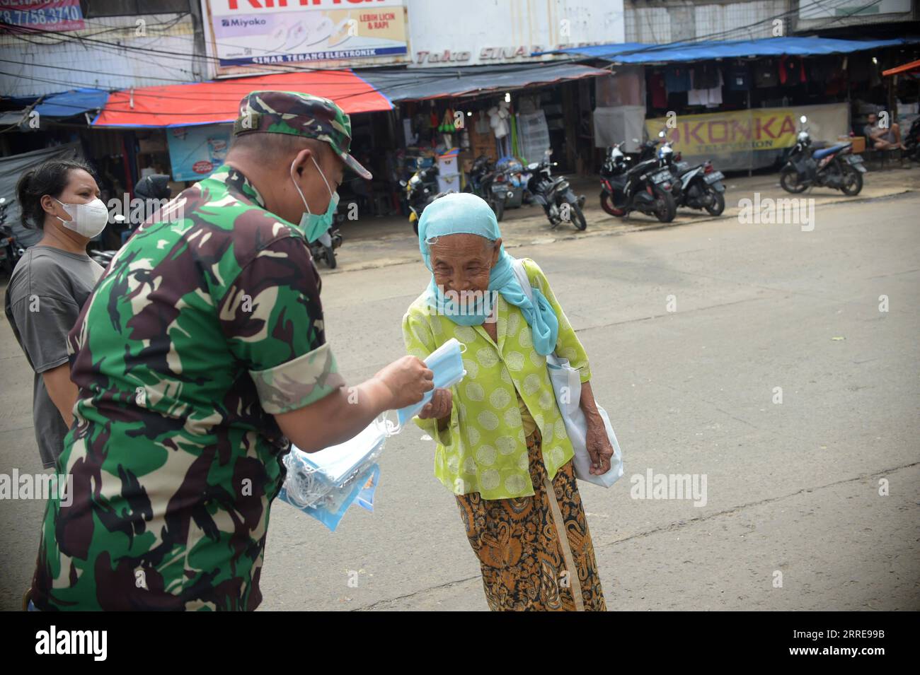 220211 -- JAKARTA, 11. Februar 2022 -- Ein Mitglied der indonesischen Armee verteilt Gesichtsmaske an einen Fußgänger in Jakarta, Indonesien, 11. Februar 2022. Die regionale Agentur für Katastrophenmanagement verteilt kostenlose Gesichtsmasken an Fußgänger und Autofahrer, um die Omicront-Variante von COVID-19 zu verhindern. INDONESIEN-JAKARTA-COVID-19-FREIE MASKE Zulkarnain PUBLICATIONxNOTxINxCHN Stockfoto