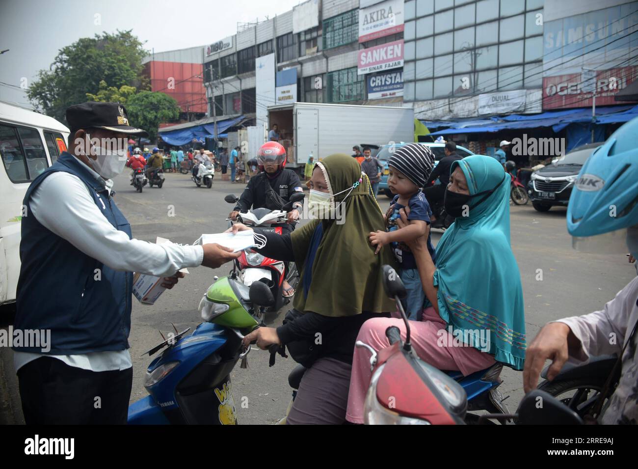 220211 -- JAKARTA, 11. Februar 2022 -- Ein Mitarbeiter verteilt Gesichtsmasken an Autofahrer in Jakarta, Indonesien, 11. Februar 2022. Die regionale Agentur für Katastrophenmanagement verteilt kostenlose Gesichtsmasken an Fußgänger und Autofahrer, um die Omicront-Variante von COVID-19 zu verhindern. INDONESIEN-JAKARTA-COVID-19-FREIE MASKE Zulkarnain PUBLICATIONxNOTxINxCHN Stockfoto