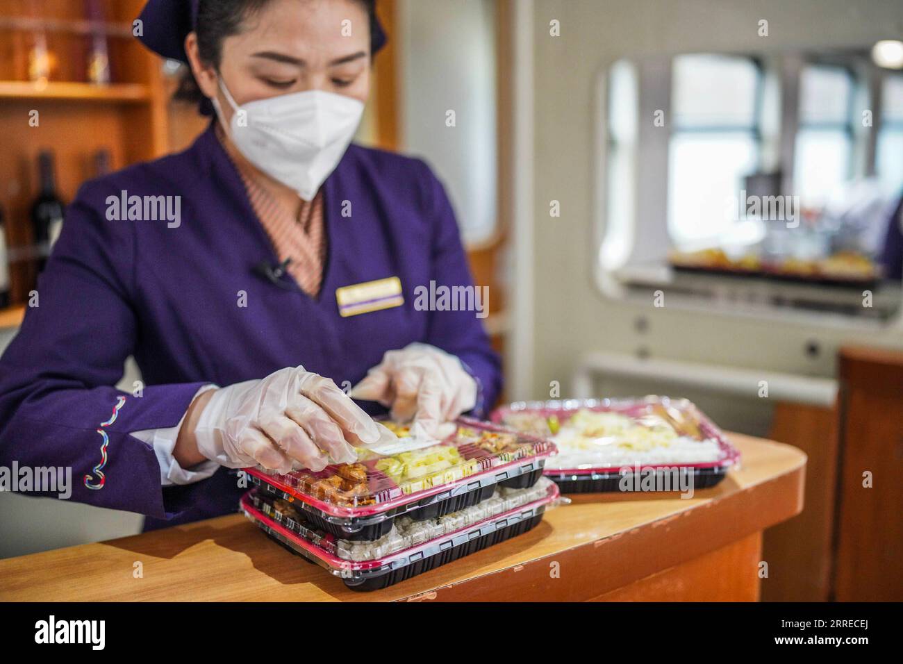 220218 -- ZHENYUAN, 18. Februar 2022 -- Tao Chunxiang klebt ein Datumsetikett auf eine verpackte Mahlzeit an Bord eines Zuges von Guiyang, Provinz Guizhou im Südwesten Chinas, nach Shanghai im Osten Chinas, 17. Februar 2022. Tao Chunxiang ist Kapitän des Shanghai Teams in der Guiyang Passenger Transport Section. Tao begann 1992 als Zugbegleiter an der Speisekarre zu arbeiten und wird Ende Februar 2022 in den Ruhestand gehen. 2006 übernahm sie die Position des Kapitäns des Speisewagens. Im Laufe der Jahre hat sie alle Mitarbeiter der Speisewagenklasse dazu gebracht, die Qualität der Mahlzeiten zu verbessern. Sie nutzt auch das Restaurant c Stockfoto