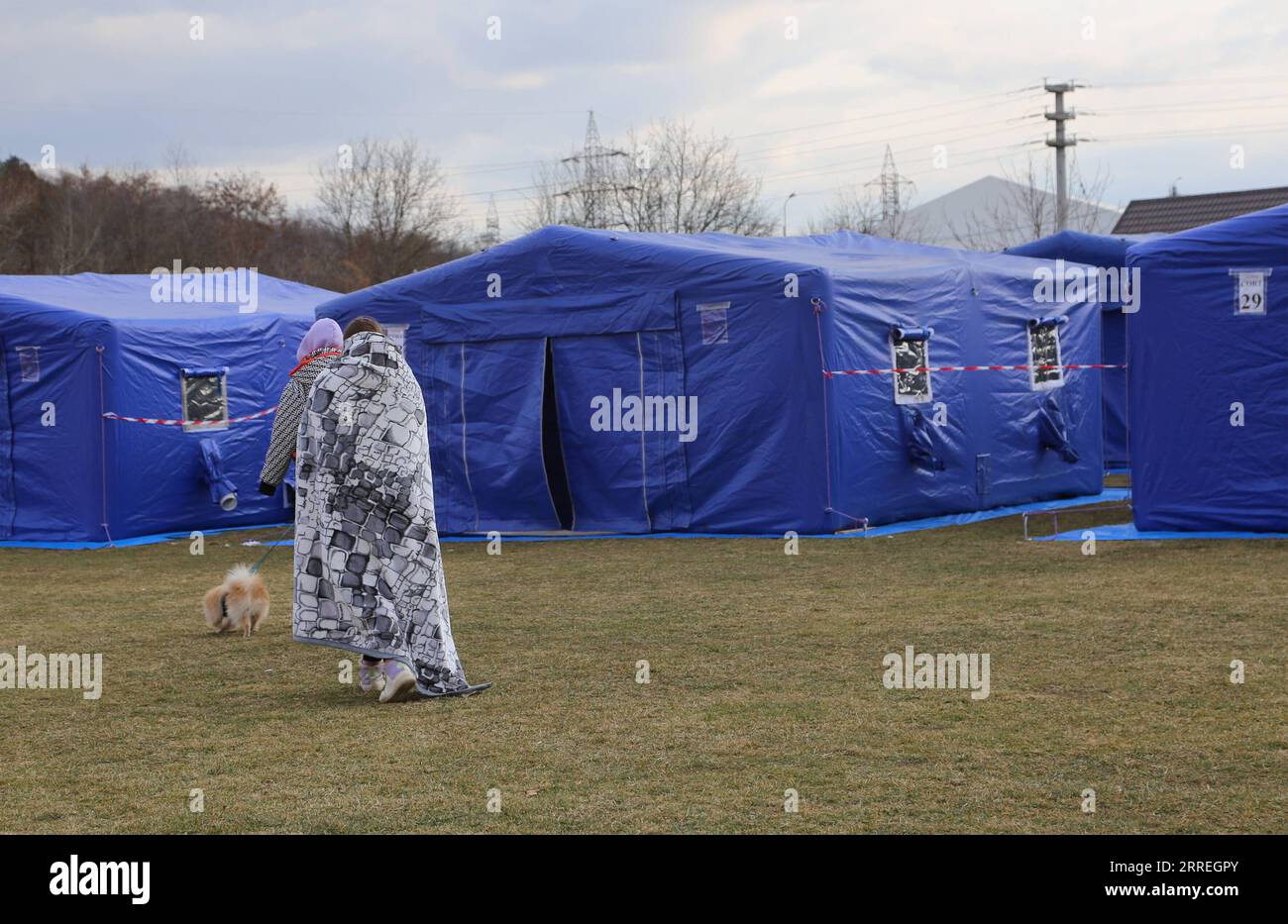 220301 -- SIRET, 1. März 2022 -- ukrainische Frauen gehen am 28. Februar 2022 mit einem Hund in der Notunterkunft in Siret, Rumänien, auf das Zelt zu. Rumänien richtete in einem Fußballstadion in Siret eine provisorische Unterkunft für Menschen aus der Ukraine ein. RUMÄNIEN-SIRET-TEMPORARY SHELTER LinxHuifen PUBLICATIONxNOTxINxCHN Stockfoto