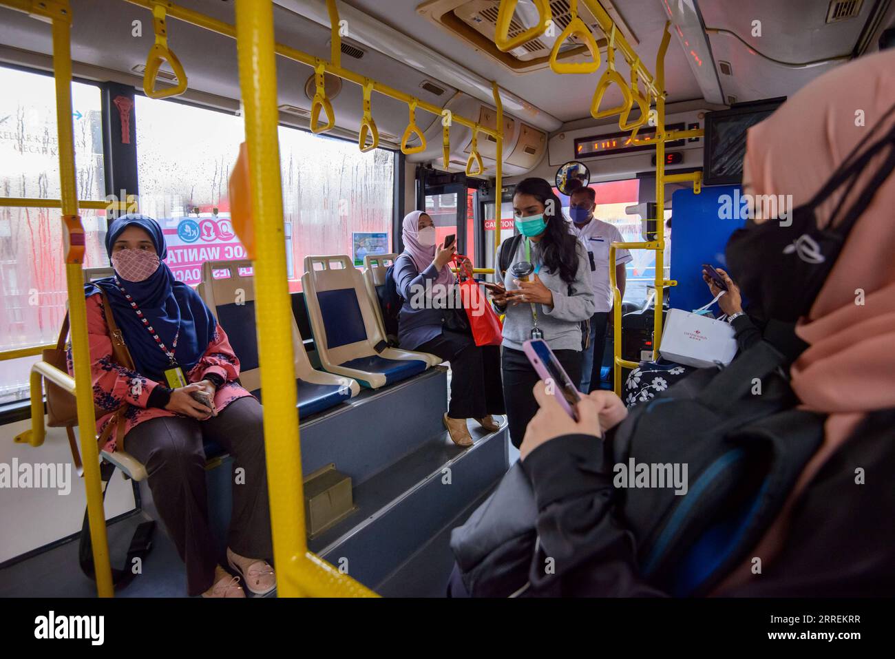 220307 -- KUALA LUMPUR, 7. März 2022 -- Frauen, die Gesichtsmasken tragen, nehmen einen Damenbus an einer Bushaltestelle in Kuala Lumpur, Malaysia, 7. März 2022. Das Kuala Lumpur City Hall begann am Montag, Frauen in den Hauptverkehrszeiten zu betreuen. Foto von /Xinhua MALAYSIA-KUALA LUMPUR-LADIES COACH ChongxVoonxChung PUBLICATIONxNOTxINxCHN Stockfoto