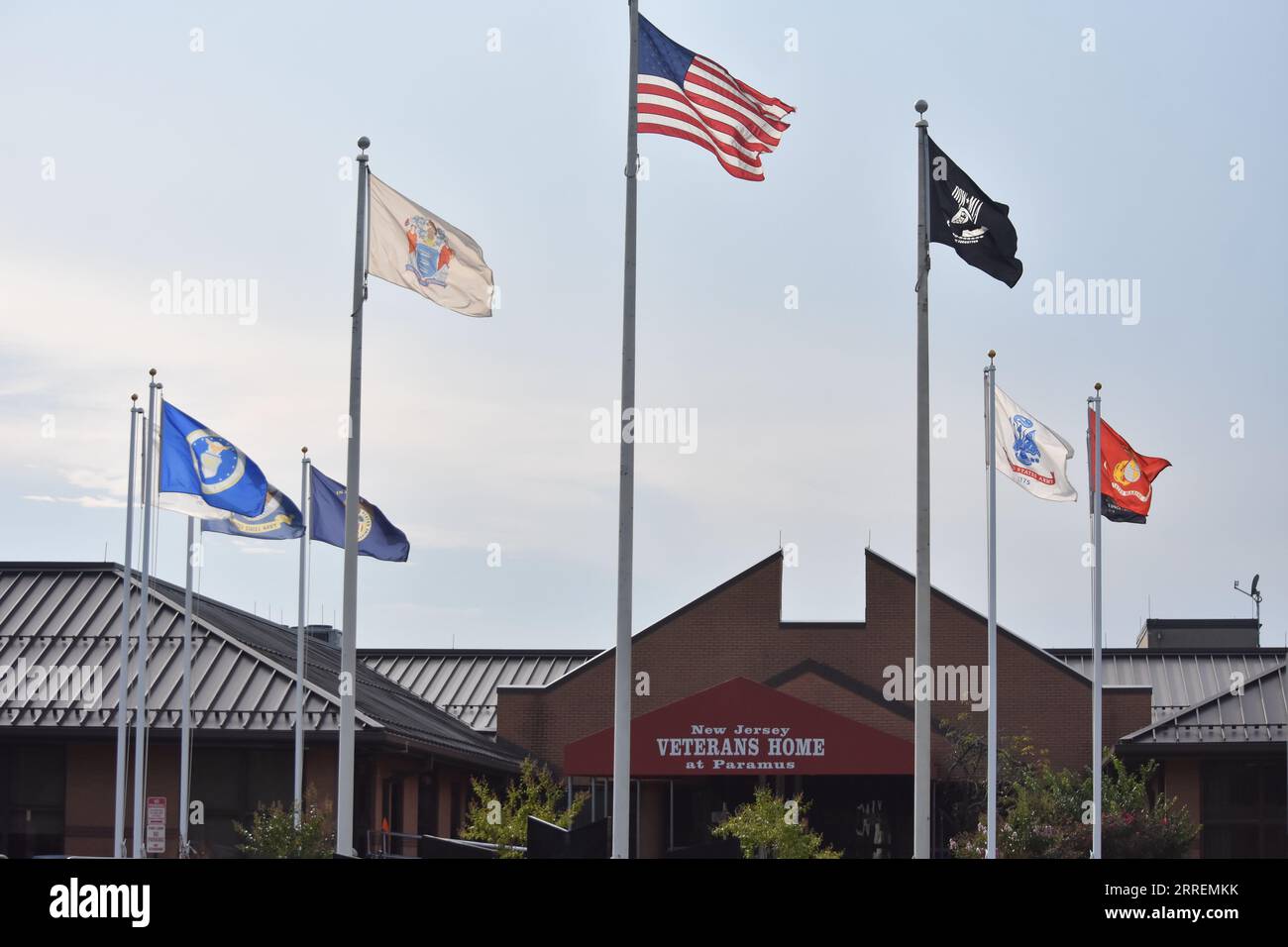 New Jersey Veterans Home im Paramus-Gebäude mit Steinen und Flaggen rund um den Haupteingang des Gebäudes. Paramus Veterans Memorial Home in Paramus. Unzureichende Pandemie-Infektionskontrolle und medizinische Versorgung in zwei staatlichen Veteranenhäusern verstießen gegen die US-Verfassung und setzten Bewohner einem Risiko für COVID-19 und andere Viren aus, sagte das Justizministerium und die US-Staatsanwaltschaft für New Jersey am Donnerstagmorgen. Die Ergebnisse in den Häusern der Veteranen von Menlo Park und Paramus berichten über einen Dolch an den Gouverneur von New Jersey, Phil Murphy, dessen Reaktion auf die Pandemie in den Pflegeeinrichtungen stark cri war Stockfoto