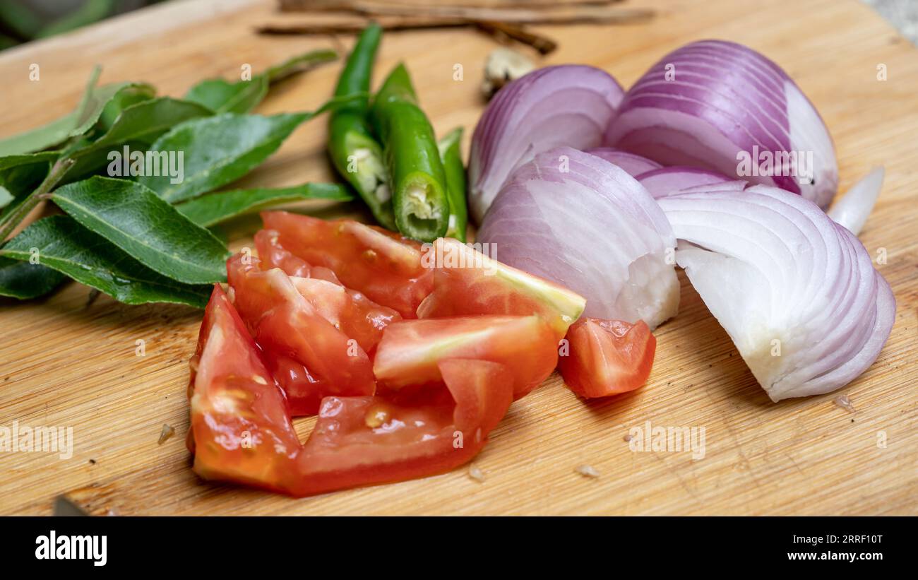 Nahaufnahme des Schneidebretts mit geschnittenen Tomaten und Zwiebeln. Stockfoto