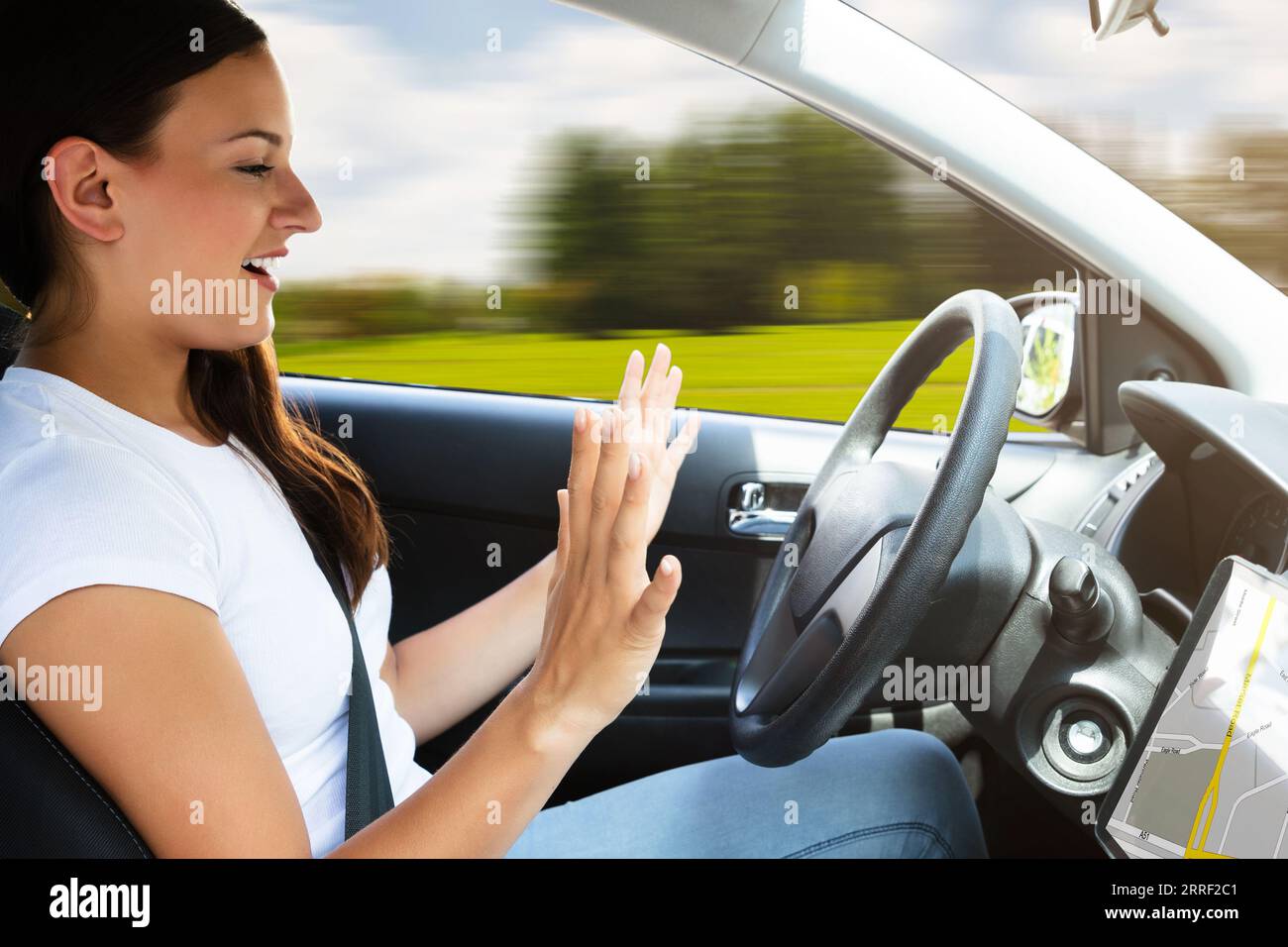 Seitliche Sicht auf eine junge Frau sitzt in modernen Autos fahren Stockfoto