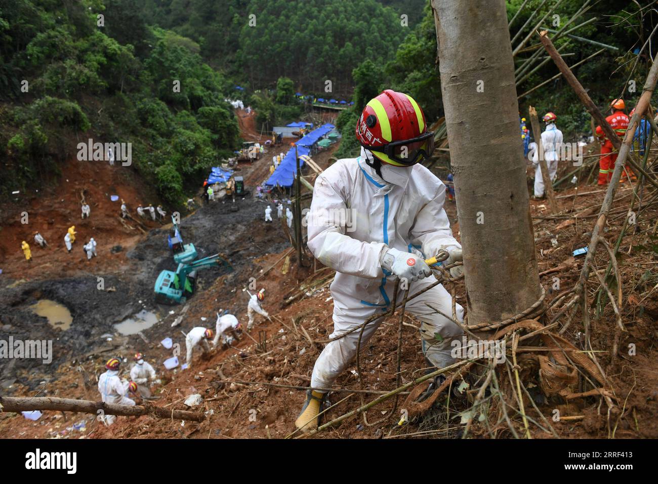 220327 -- TENGXIAN, 27. März 2022 -- Ein Retter bindet ein Sicherheitsseil an einen Baum an der Flugzeugabsturzstelle im Tengxian County, südchinesische autonome Region Guangxi Zhuang, 26. März 2022. Alle 132 Menschen an Bord des Flugzeugs der China Eastern Airlines, das am Montag in der autonomen Region Guangxi Zhuang in Südchina abstürzte, waren tot, wie ein Beamter am Samstag mitteilte. Die nationale Notfallzentrale für den Flugzeugunglück der China Eastern Airlines Flug MU5735 am 21. März gab die Ankündigung auf einer Pressekonferenz am späten Abend am Samstag nach sechs Tagen voller Such- und Rettungsbemühungen bekannt. CHINA-GU Stockfoto