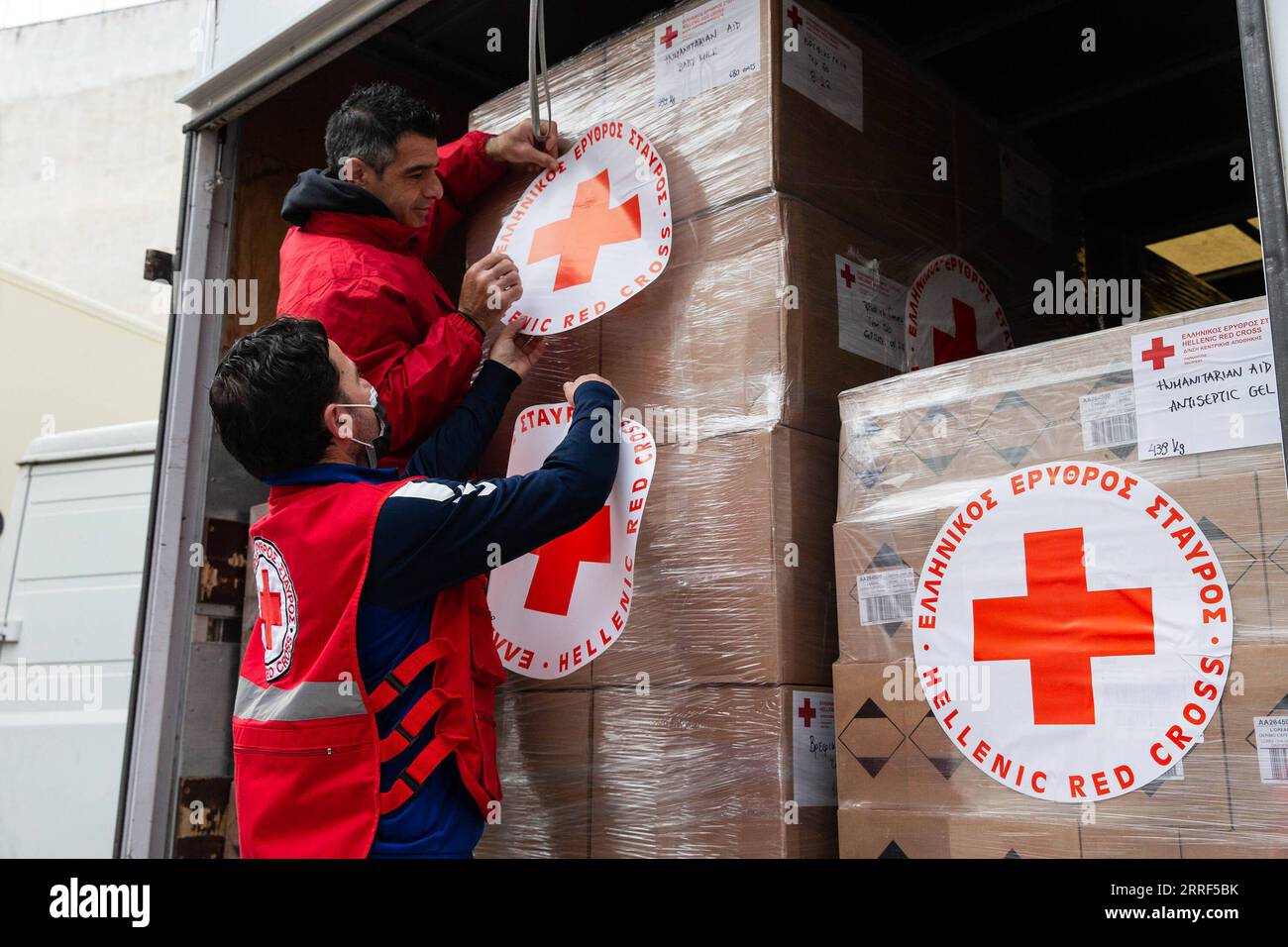 220330 -- ATHEN, 30. März 2022 -- Freiwillige des Hellenischen Roten Kreuzes arbeiten an dem LKW, der mit humanitärer Hilfe für die Ukraine in Athen, Griechenland, am 29. März 2022 beladen ist. Das Hellenische Rote Kreuz hat am Dienstag 50 Tonnen humanitäre Hilfe in die Ukraine geschickt. GRIECHENLAND-ATHEN-HELLENISCHES ROTES KREUZ-UKRAINE-HUMANITÄRE HILFE MARIOSXLOLOS PUBLICATIONXNOTXINXCHN Stockfoto