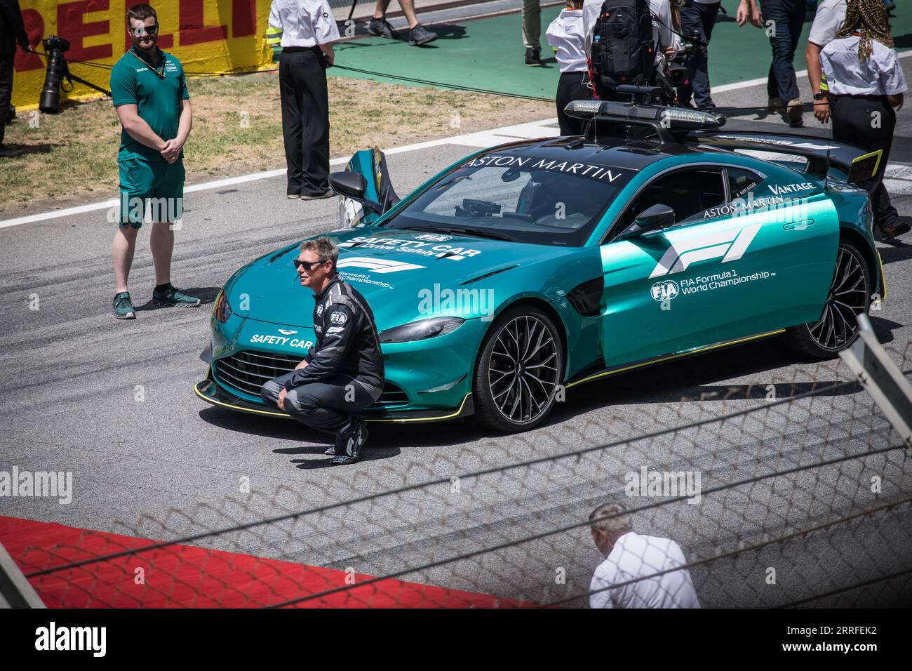 Bernd Maylander, der offizielle Formel 1-Fahrer des Safety Car, kniete kurz vor dem Rennen neben dem legendären Aston Martin Safety Car. Stockfoto