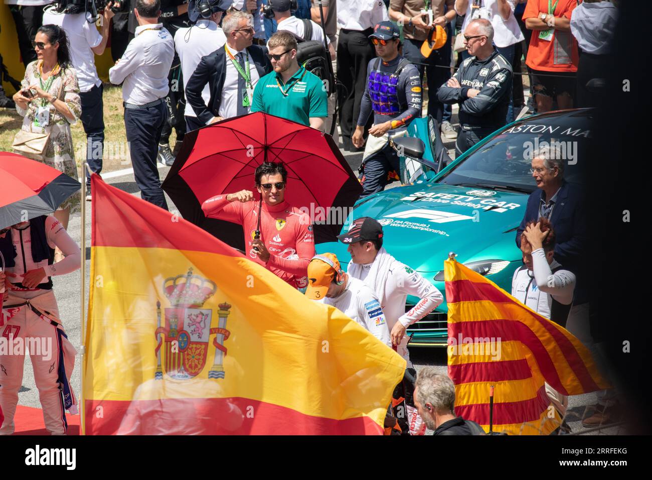 Carlos Sainz, F1-Fahrer, ein Moment vor dem Hintergrund der Menschenmenge. Im Vordergrund ist eine spanische Flagge zu sehen. Stockfoto