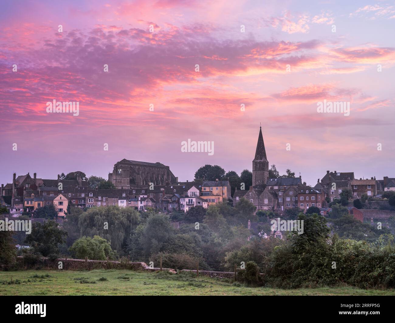 Freitag, 8. September 2023. Malmesbury, Wiltshire, England - Ein warmer und feuchter Start in den Tag in Wiltshire. Der Nebel lässt sich über der Wasserwiese und der Himmel wird rosa, während die Sonne hinter der Stadt Malmesbury aufgeht. Das historische Kloster wurde 676 als Benediktinerkloster gegründet und ist das dominierende Merkmal der malerischen Marktgemeinde Wiltshire. Quelle: Terry Mathews/Alamy Live News Stockfoto