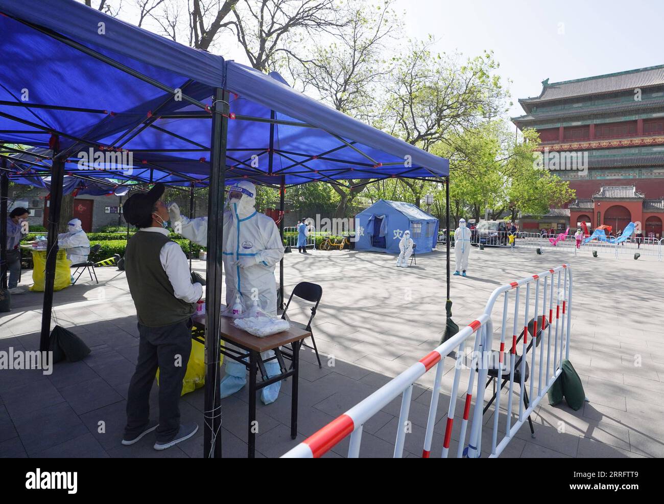 220426 -- PEKING, 26. April 2022 -- Ein medizinischer Arbeiter nimmt eine Abstrichprobe von einem Bürger an einer Nukleinsäure-Teststelle während eines Massentests auf COVID-19 im Bezirk Dongcheng, Peking, Hauptstadt von China, am 26. April 2022. Peking wird von Dienstag bis Samstag drei Nukleinsäuretests in elf Gebieten durchführen, um das COVID-19-Risiko einzudämmen, sagten die lokalen Behörden auf einer Pressekonferenz am Montag. Die Tests werden Menschen in den Bezirken Xicheng, Dongcheng, Haidian, Fengtai, Shijingshan, Fangshan, Tongzhou, Shunyi, Changping, Daxing und Beijing Economic-Technological Development Stockfoto